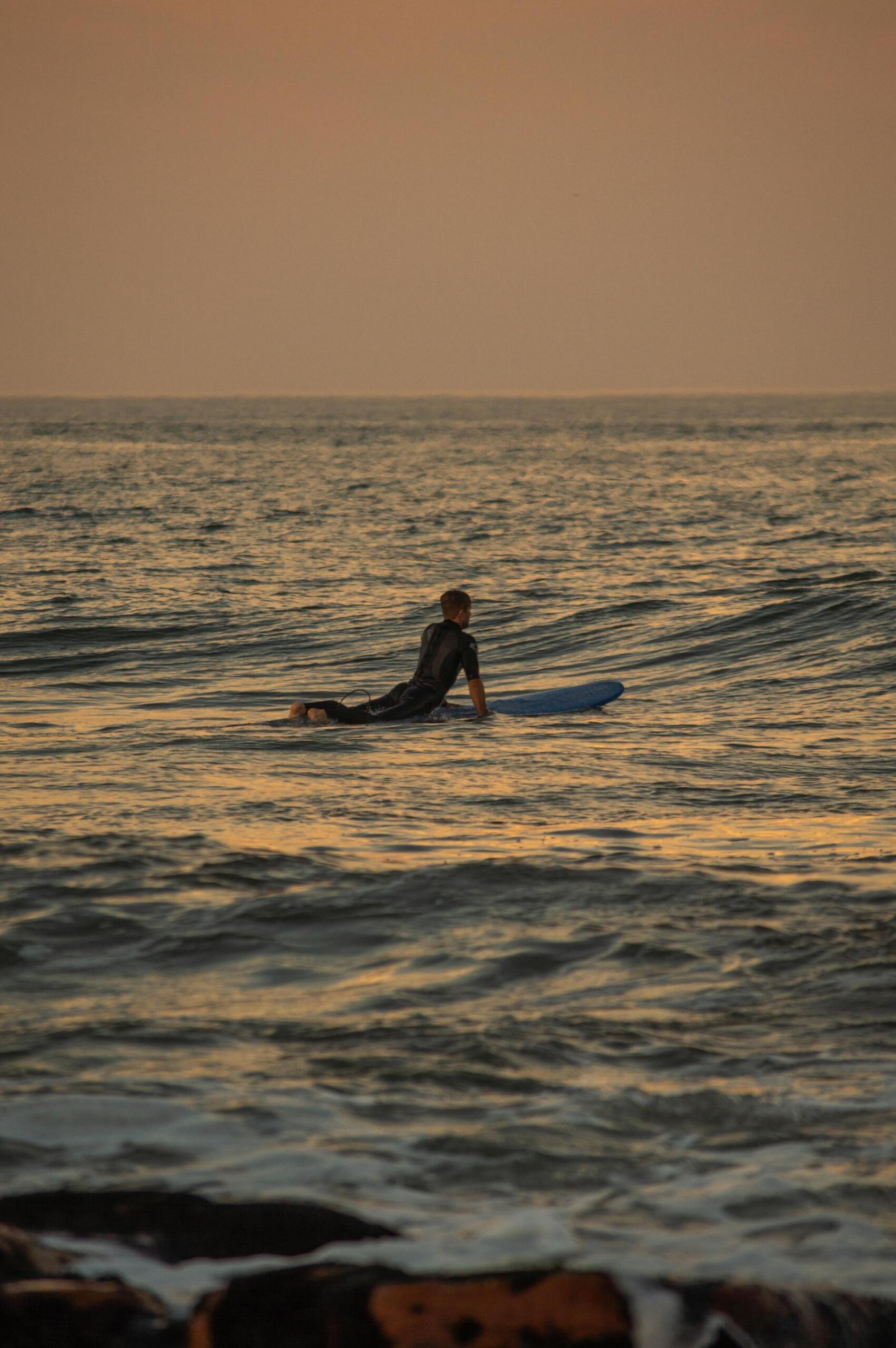 surfista deitado em cima da prancha