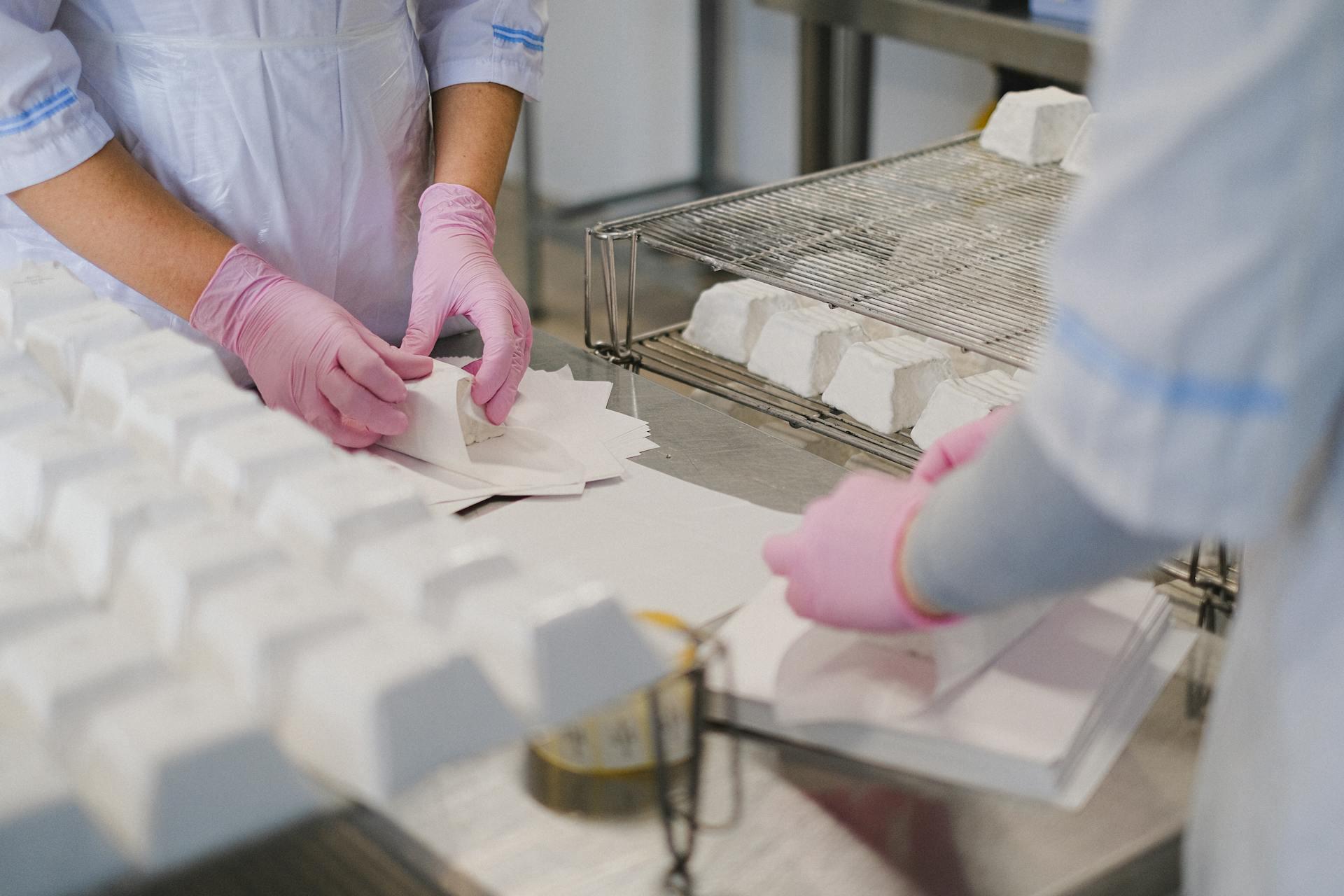 duas pessoas com luvas a embalar produtos