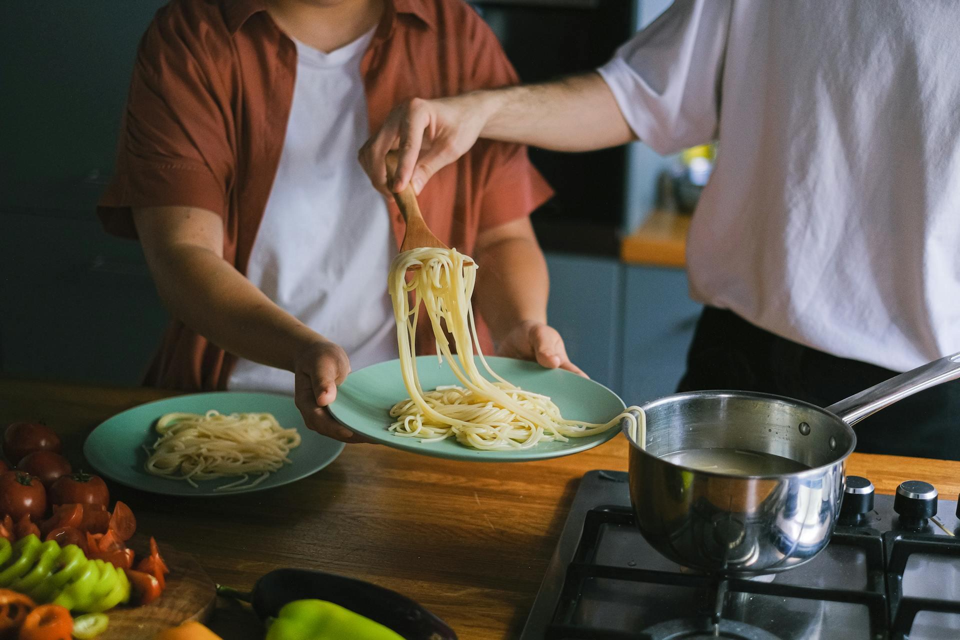 dois homens na cozinha a fazer massa