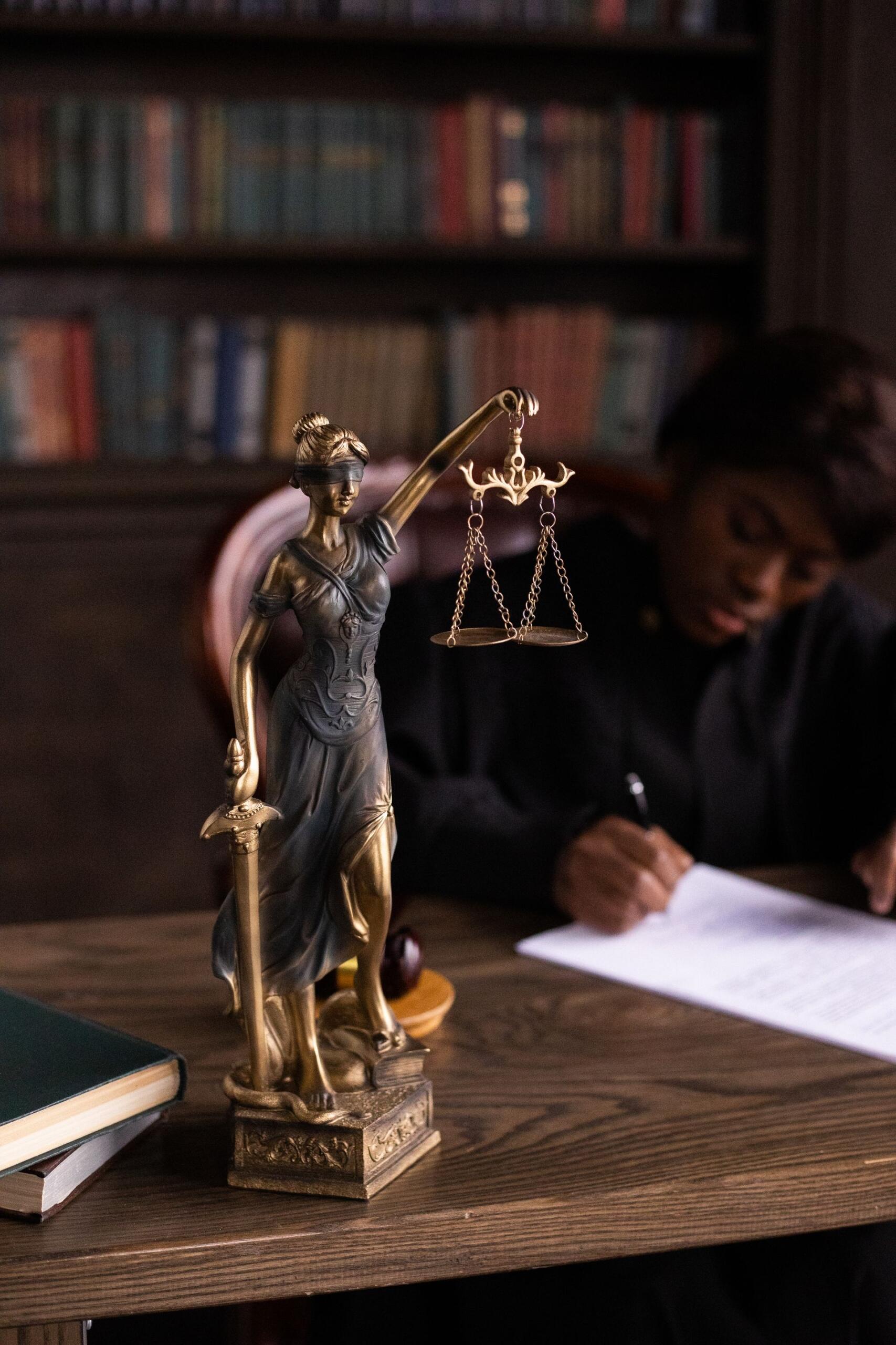 estátua da justiça em cima de uma secretária
