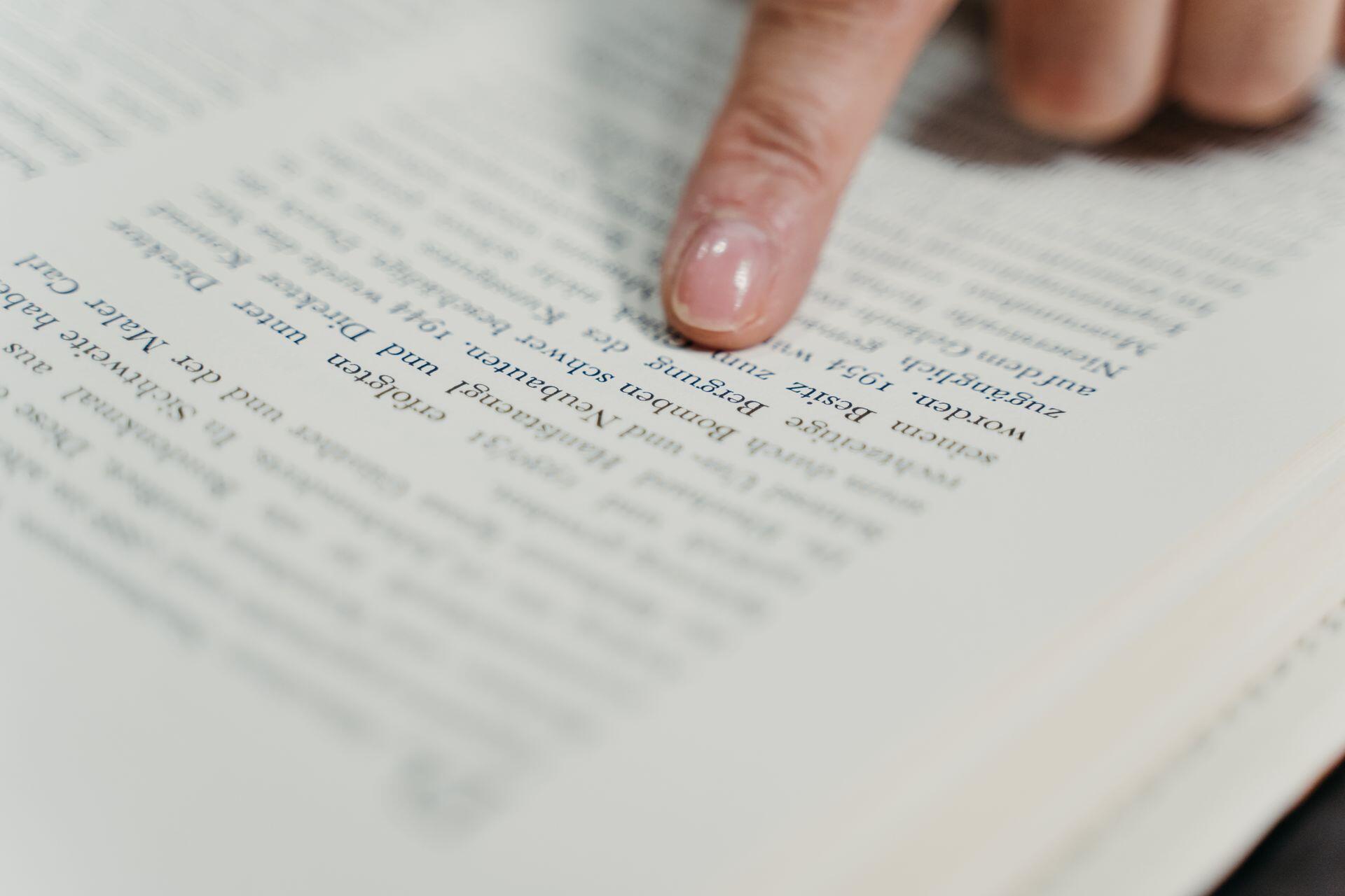pessoa a seguir linha de livro com o dedo