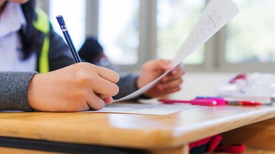 معلم يقوم بتصحيح اختبارات الطلبة.