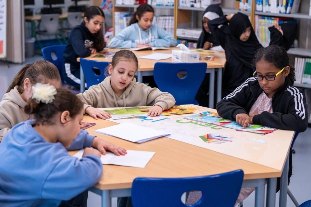 مجموعة من الطلاب يجلسون في الغرفة الصفية، ويشاركون في أحد النشاطات الفنية.