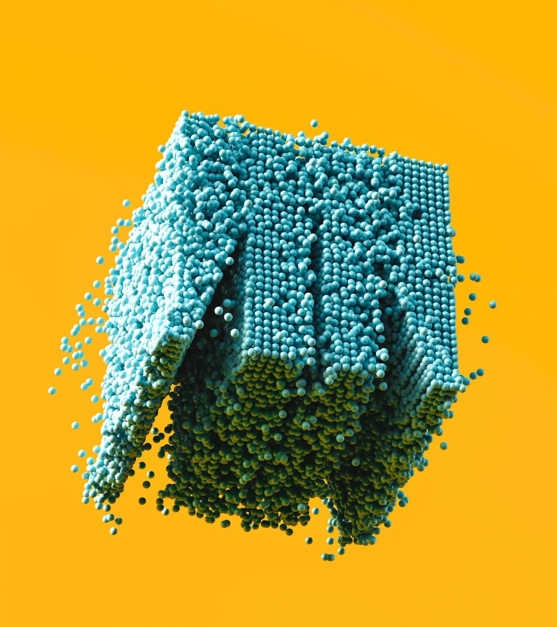 تصميم تجريدي ثلاثي الأبعاد يظهر مكعباً يتفكك ويتناثر إلى آلاف الكرات الزرقاء الصغيرة على خلفية صفراء زاهية.