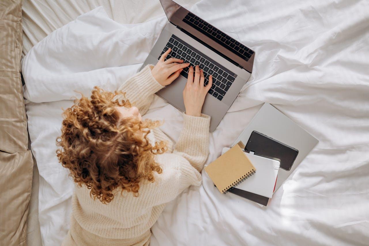 fille travaillant dans son lit