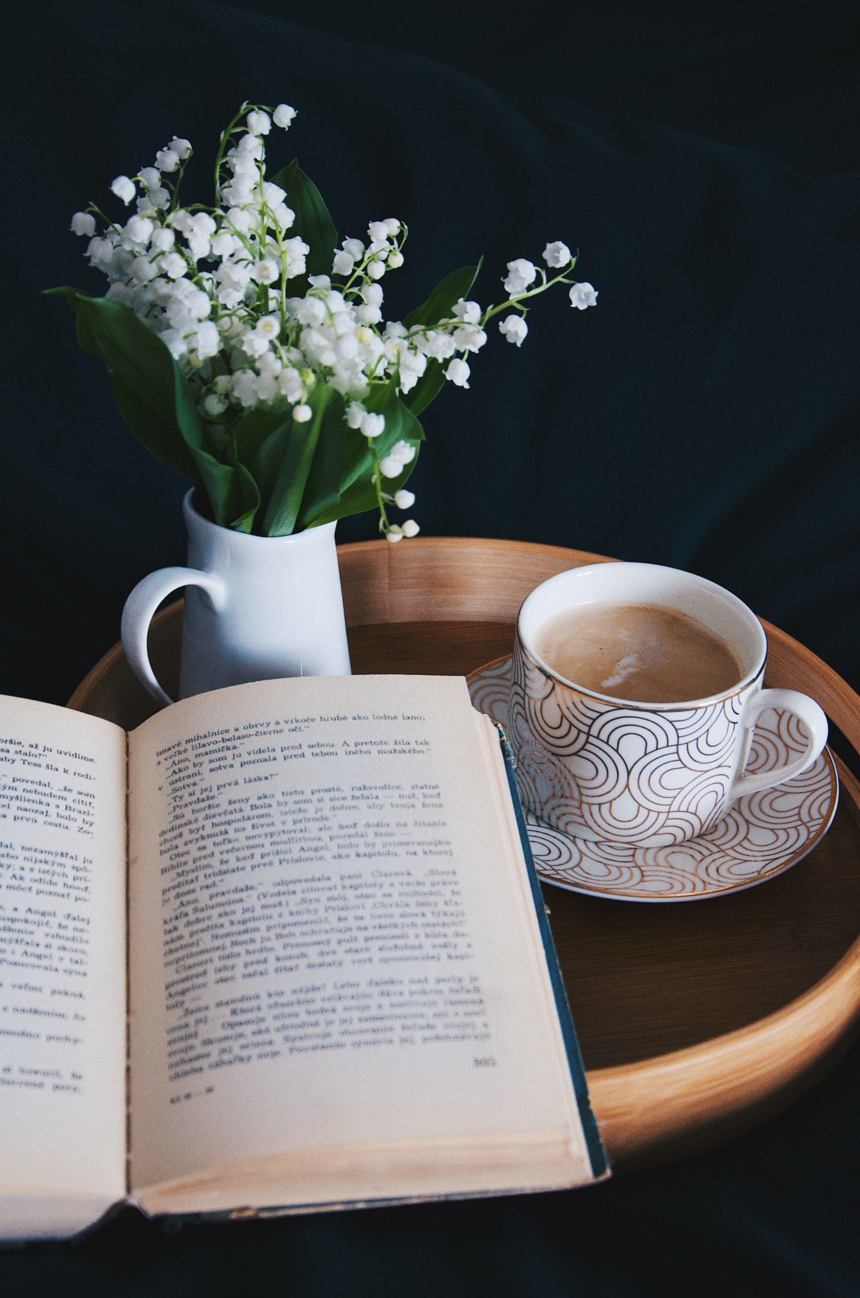 Un livre ouvert et une tasse de thé au lait.