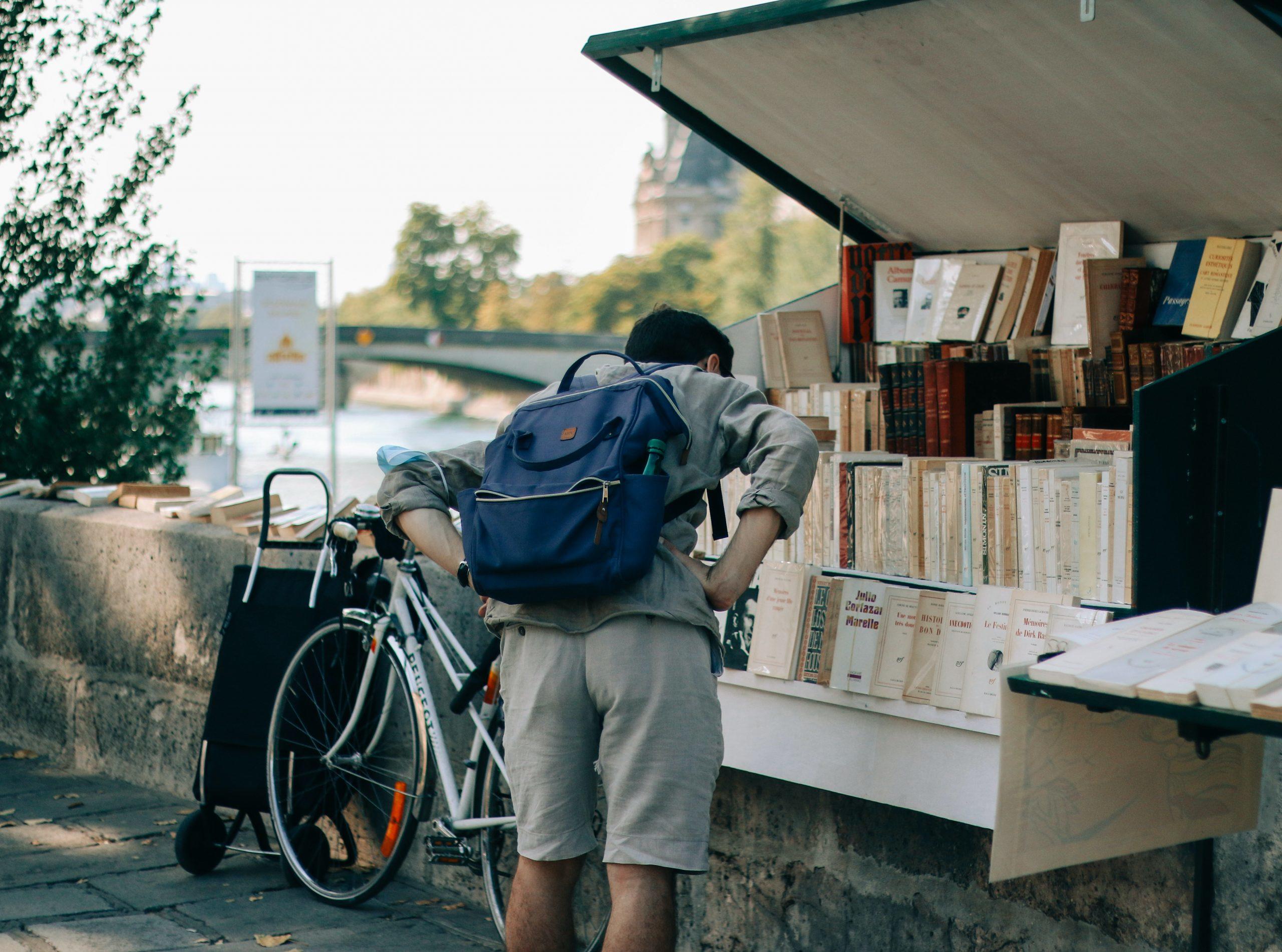 Un homme regarde des livres sur les quais de Seine.