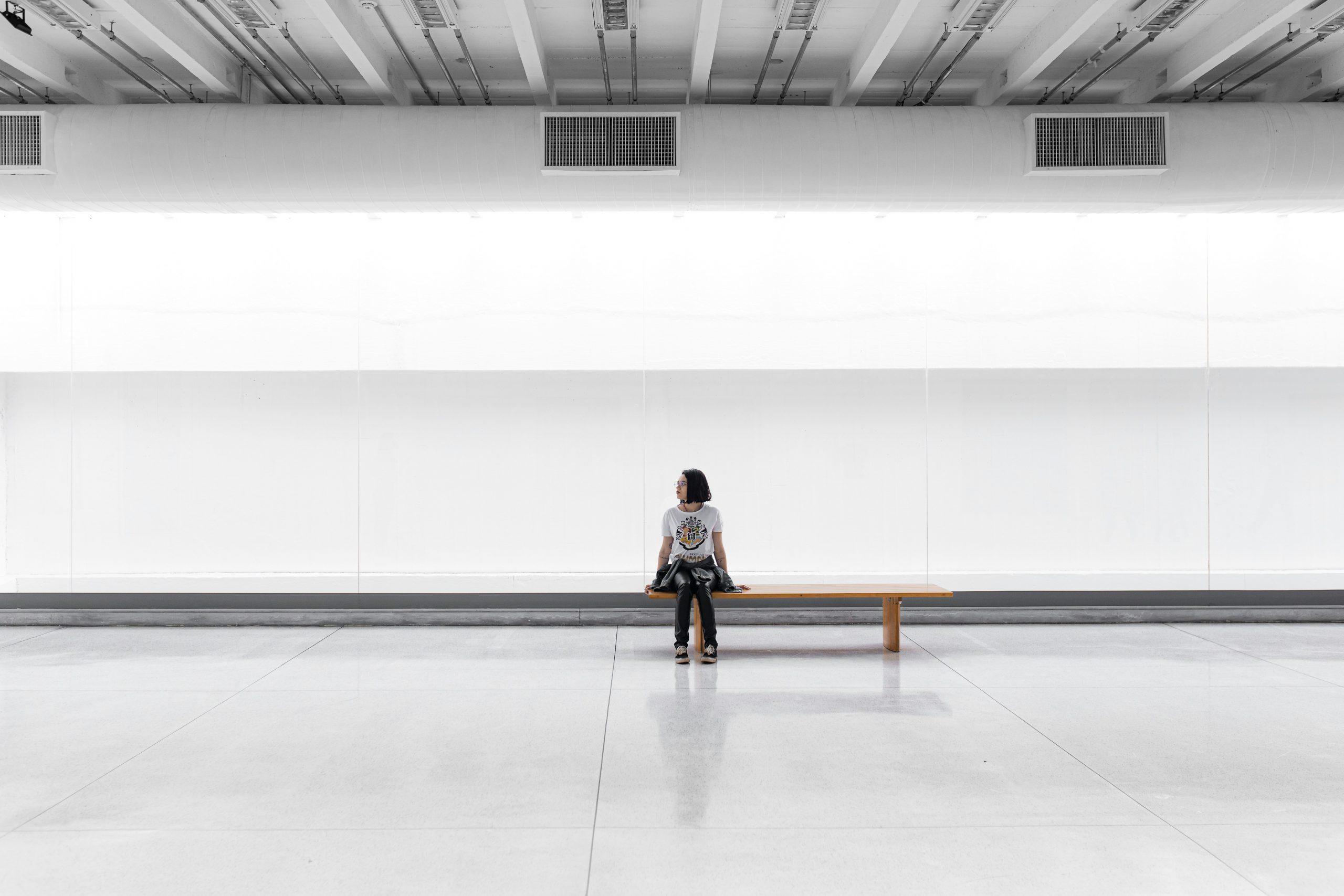 Une femme est assise sur un banc dans un musée.