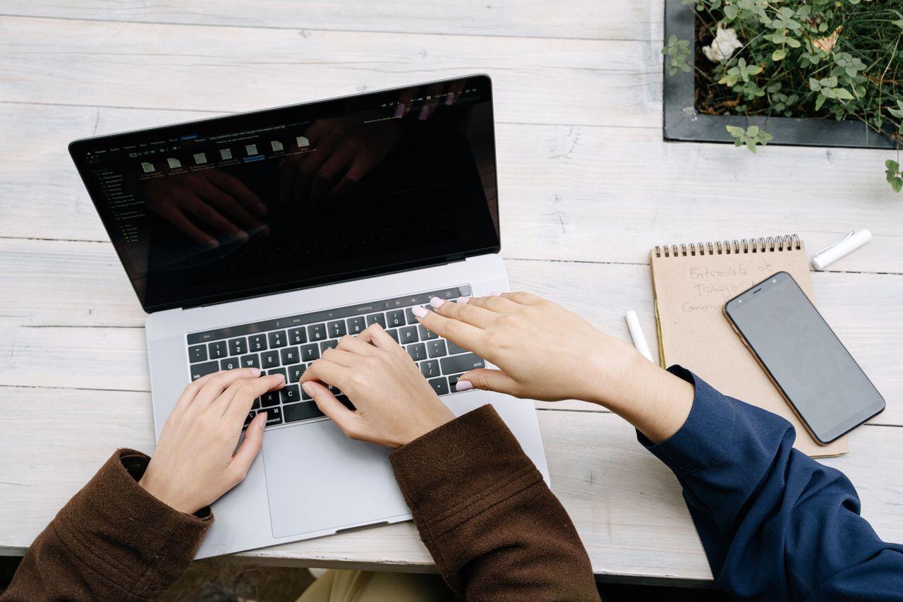 trois mains sur un laptop pour travailler