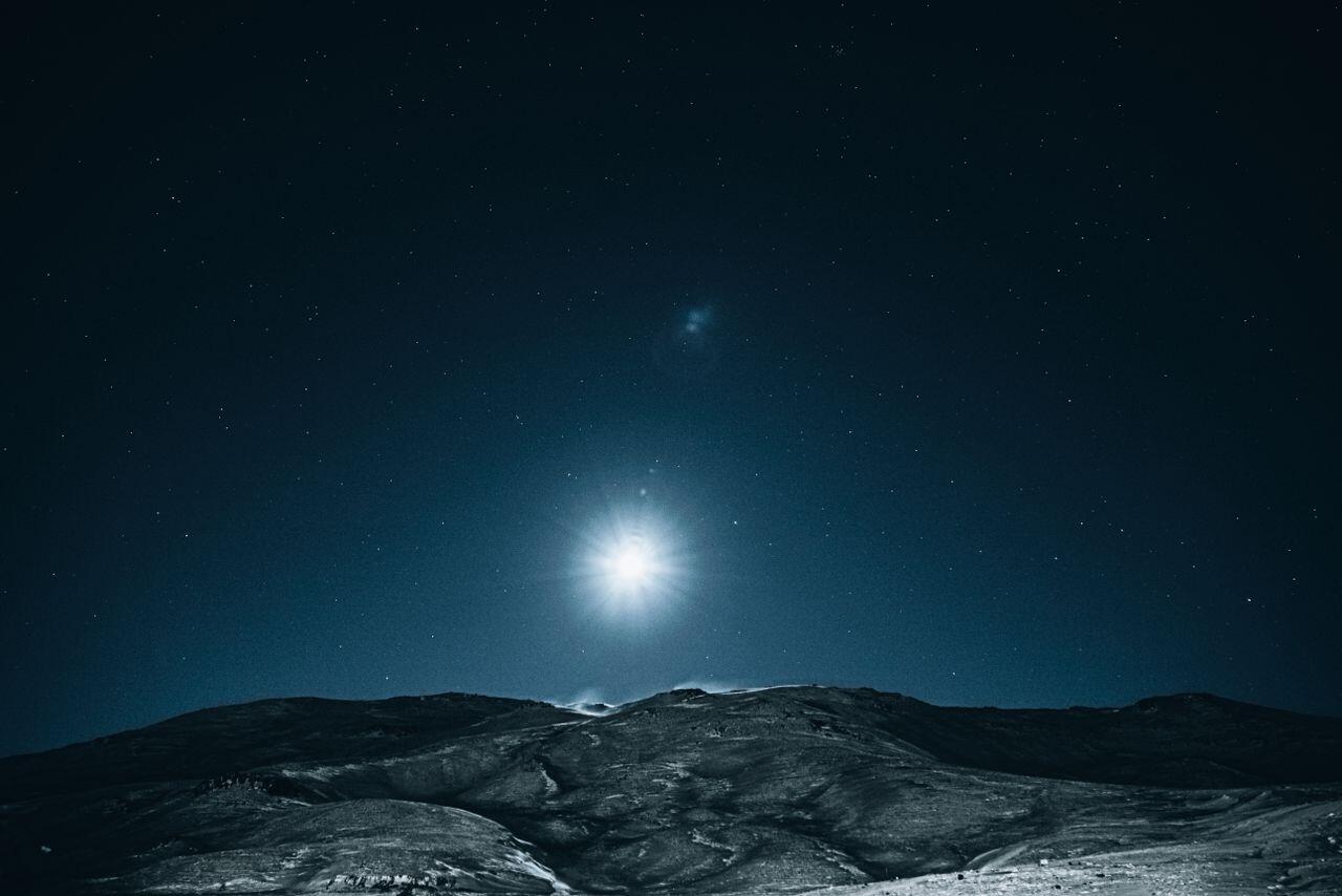 lune brillante daans la nuit au dessus de la montagne