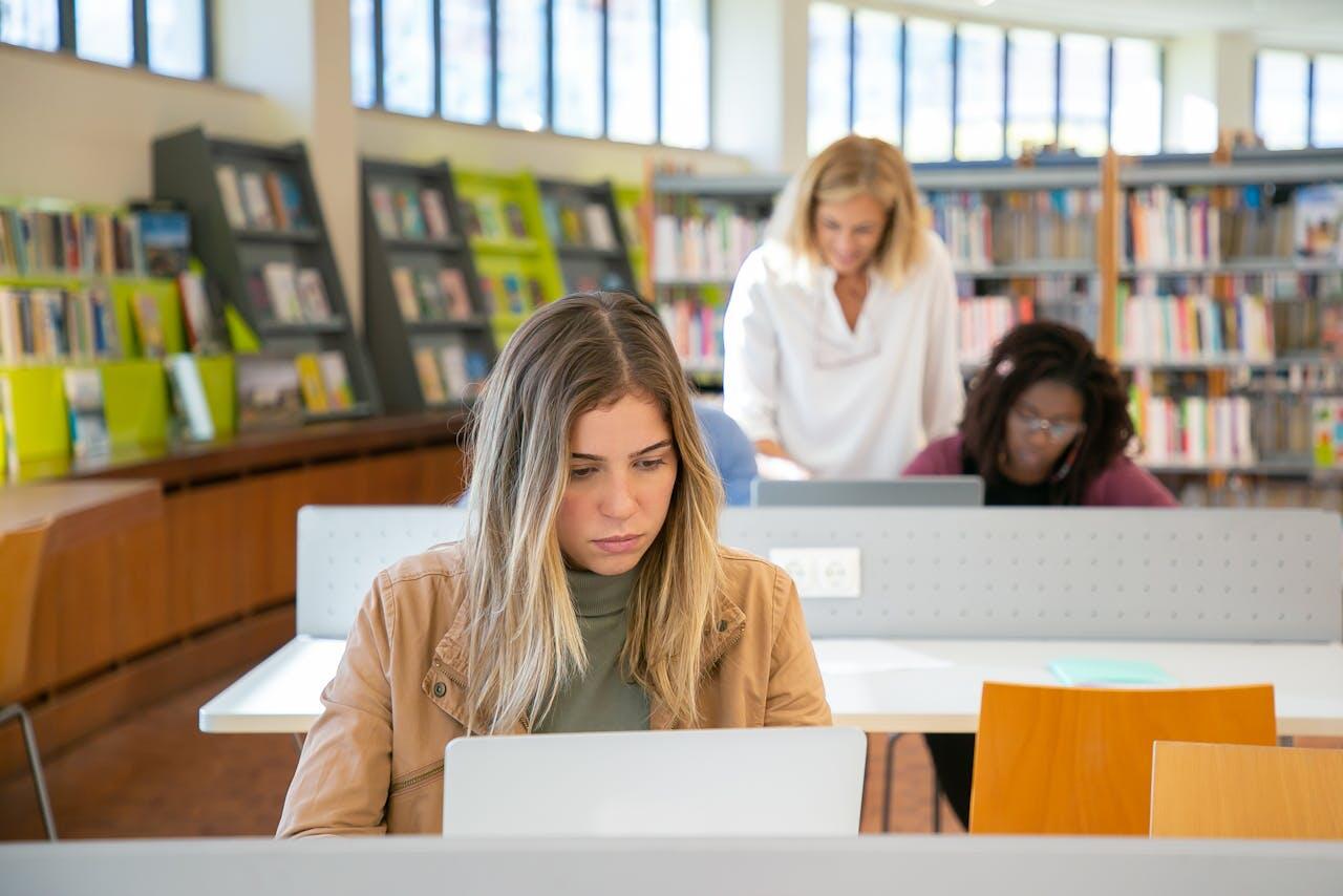 etudiante dans une bibliotheque etudiant avec son ordi