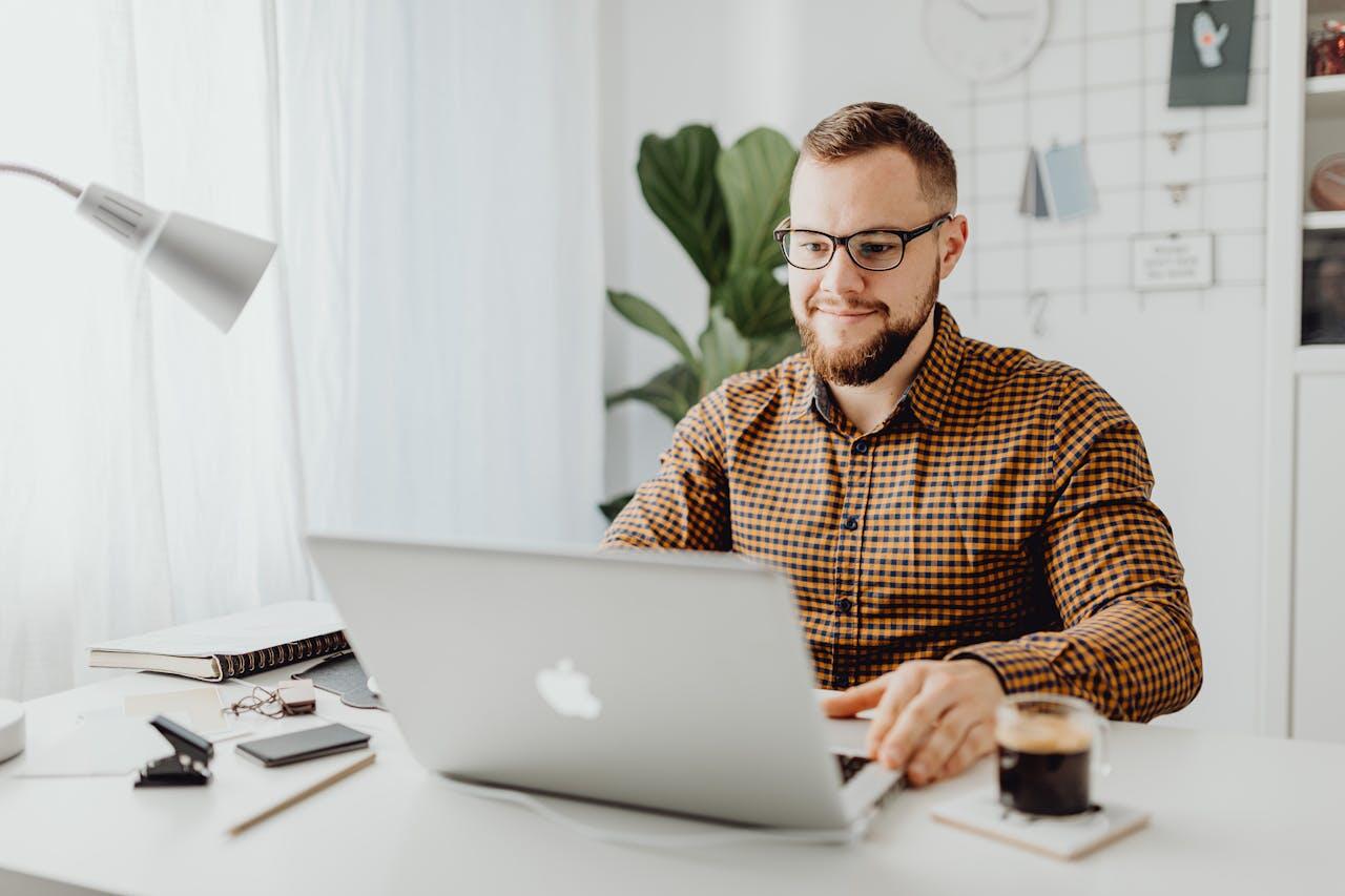 homme en chemise travaillant sur l ordi