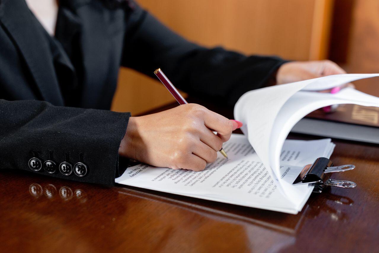 main d une femme manucuree remplissant un dossier