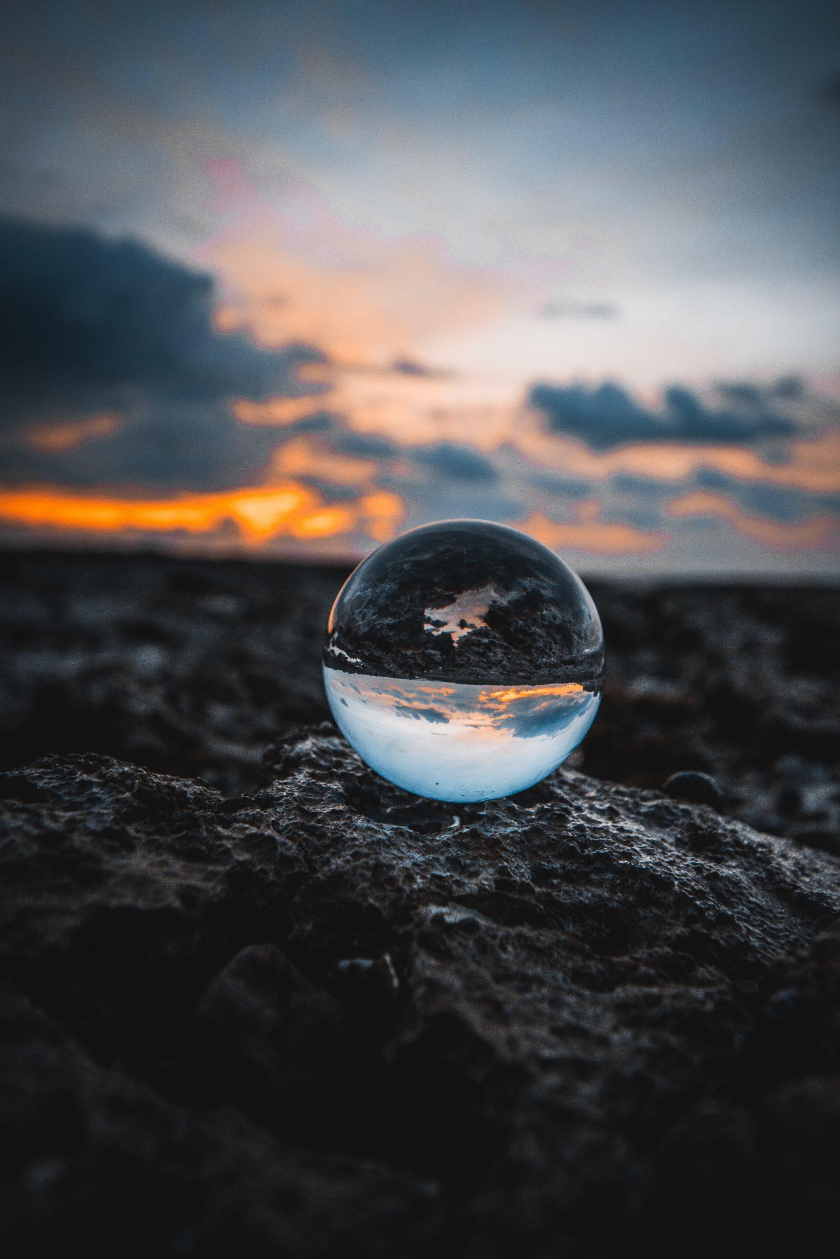 Une bille transparente posée sur la terre.