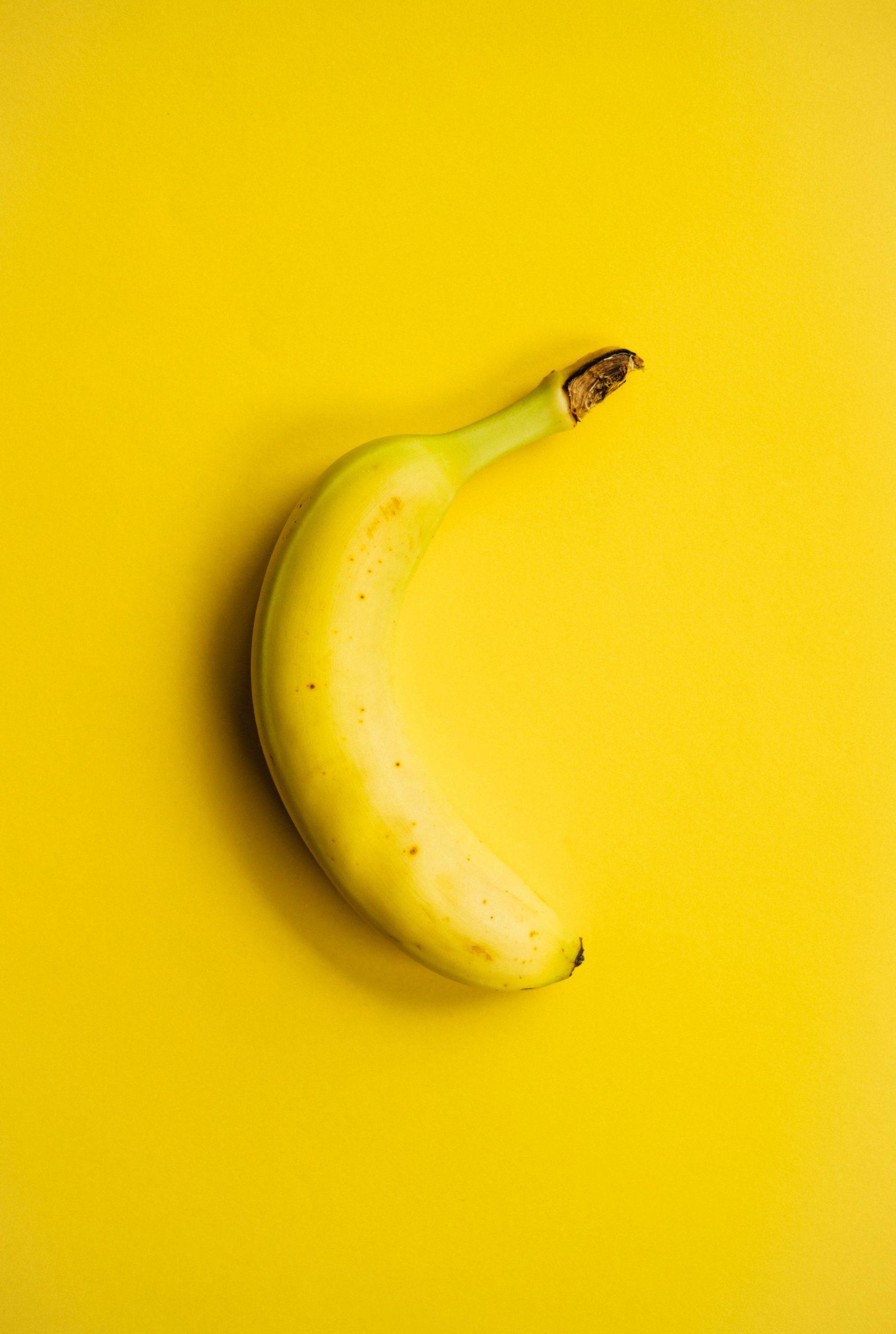 Une banane sur un fond jaune.