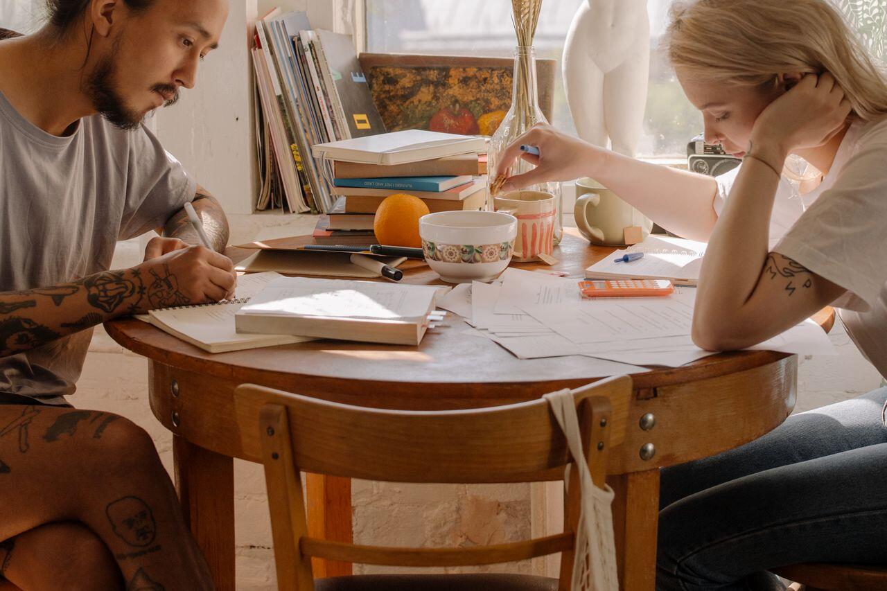 deux jeunes etusiant sur la table de la cuisine du petit dejeuner