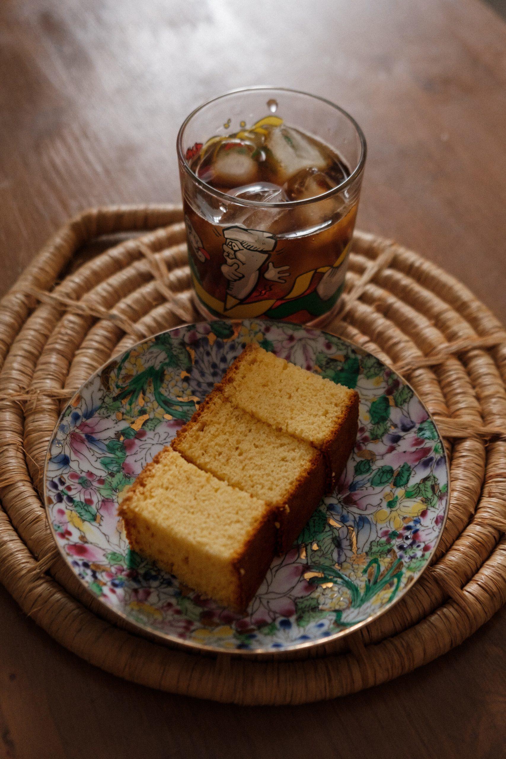 Une part de cake et un verre de thé glacé sur un plateau.