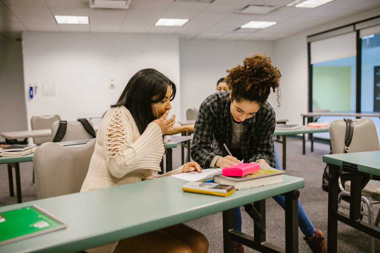 deux jeunes dans leur salle de classe s entraitant sur un travail