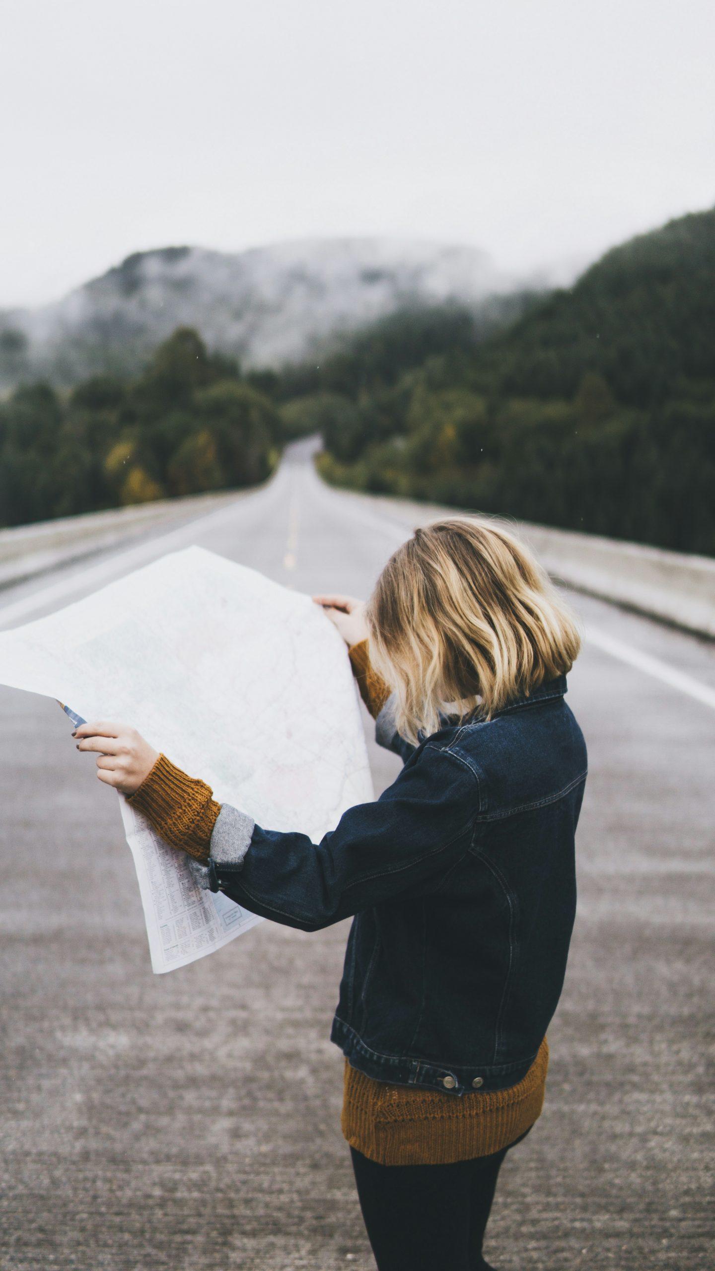 Une femme cherche son chemin avec une carte.