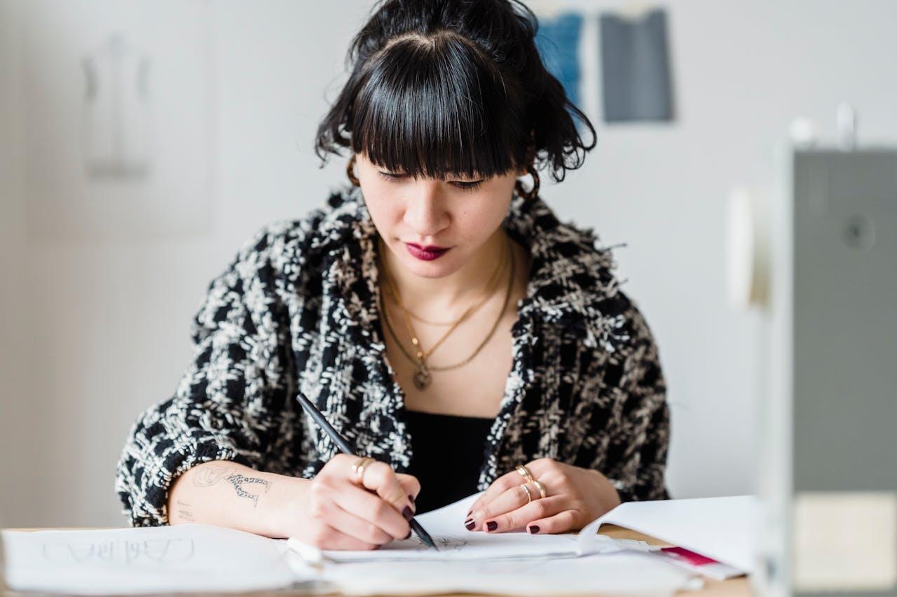 jeune femme bien appretee etudiant sur ses bouquins sur une table