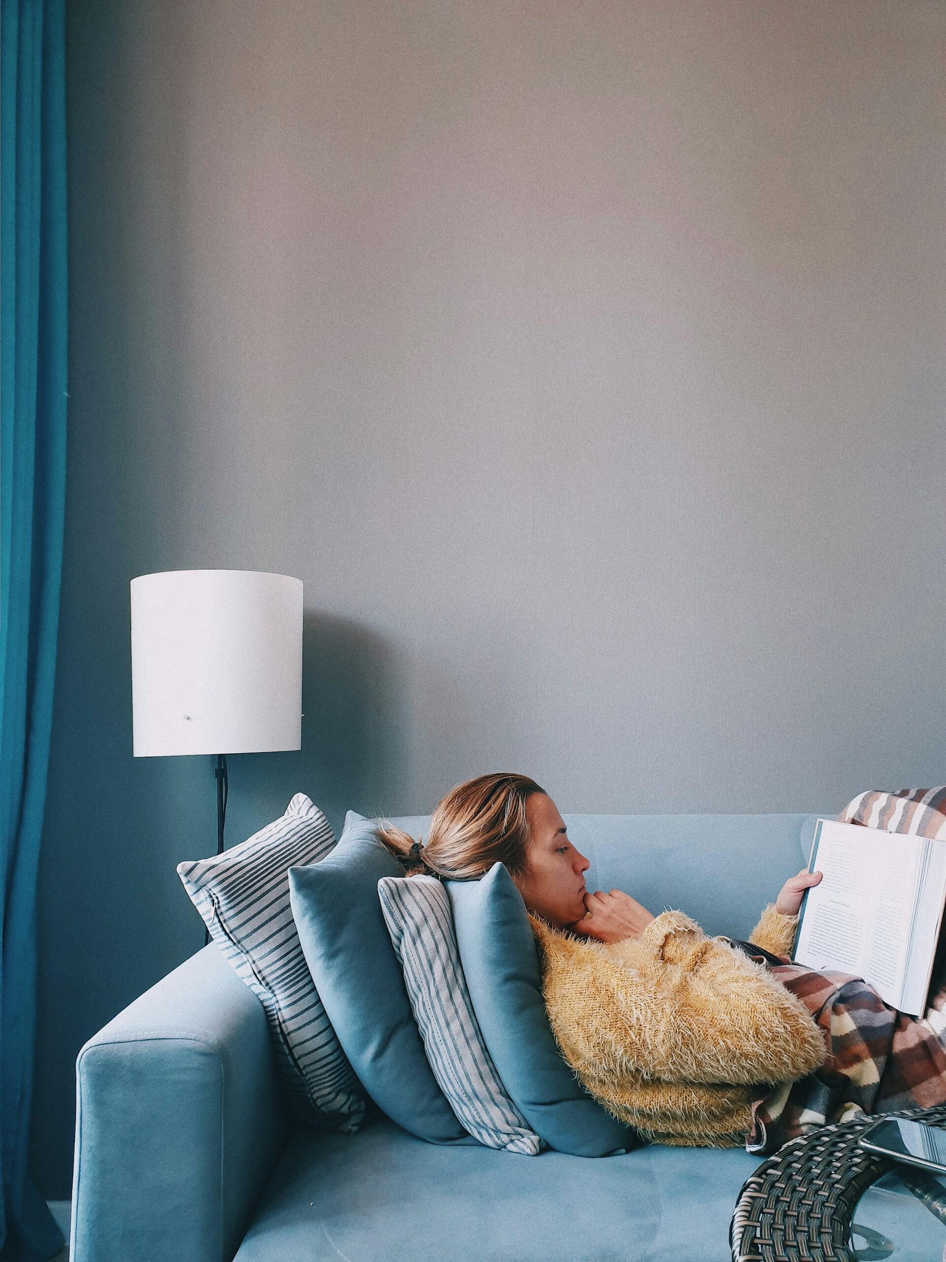 femme lisant un livre sur le canapé