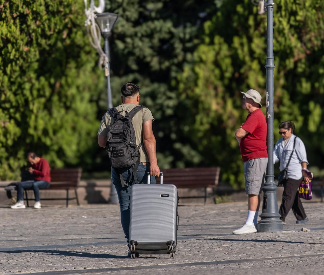 homme de dos en valise dans la rue