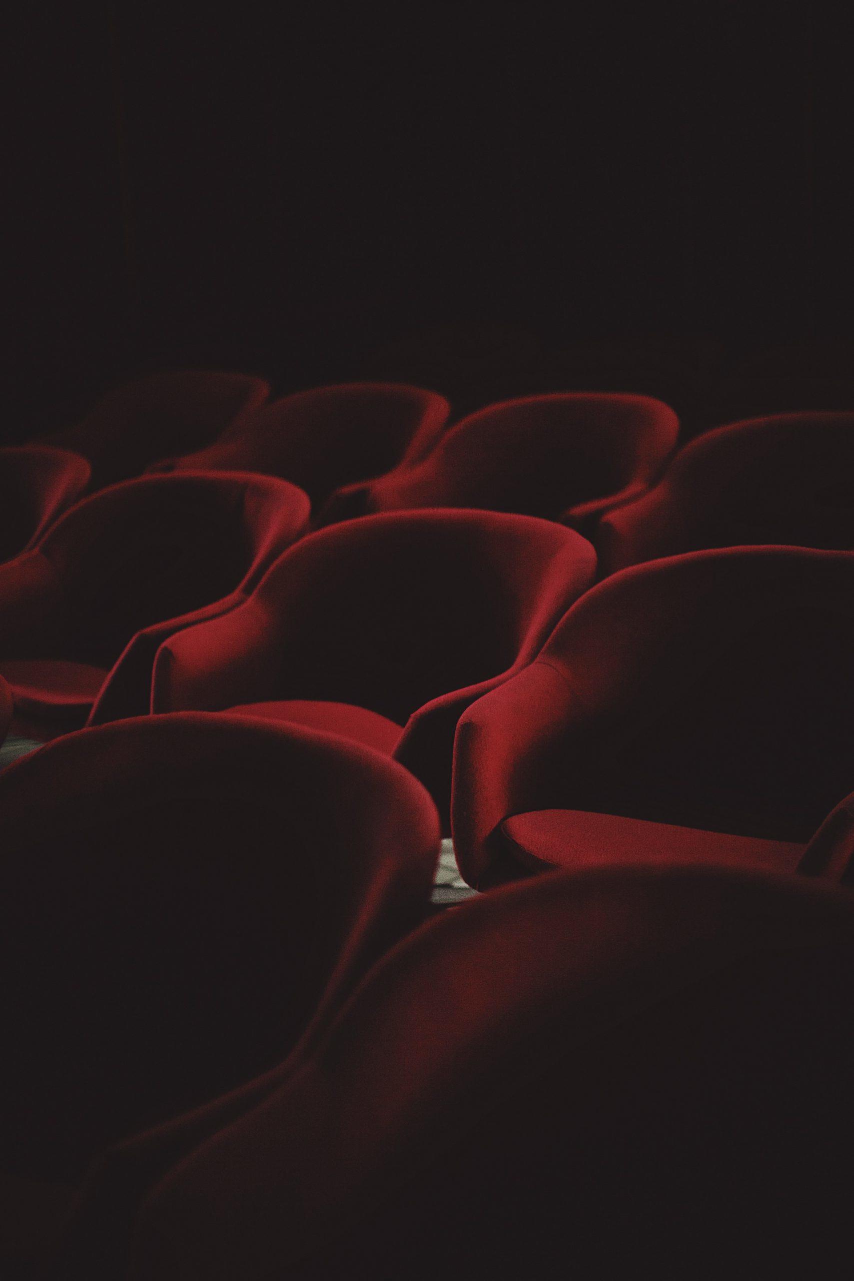 Des sièges de théâtre dans une salle sombre.