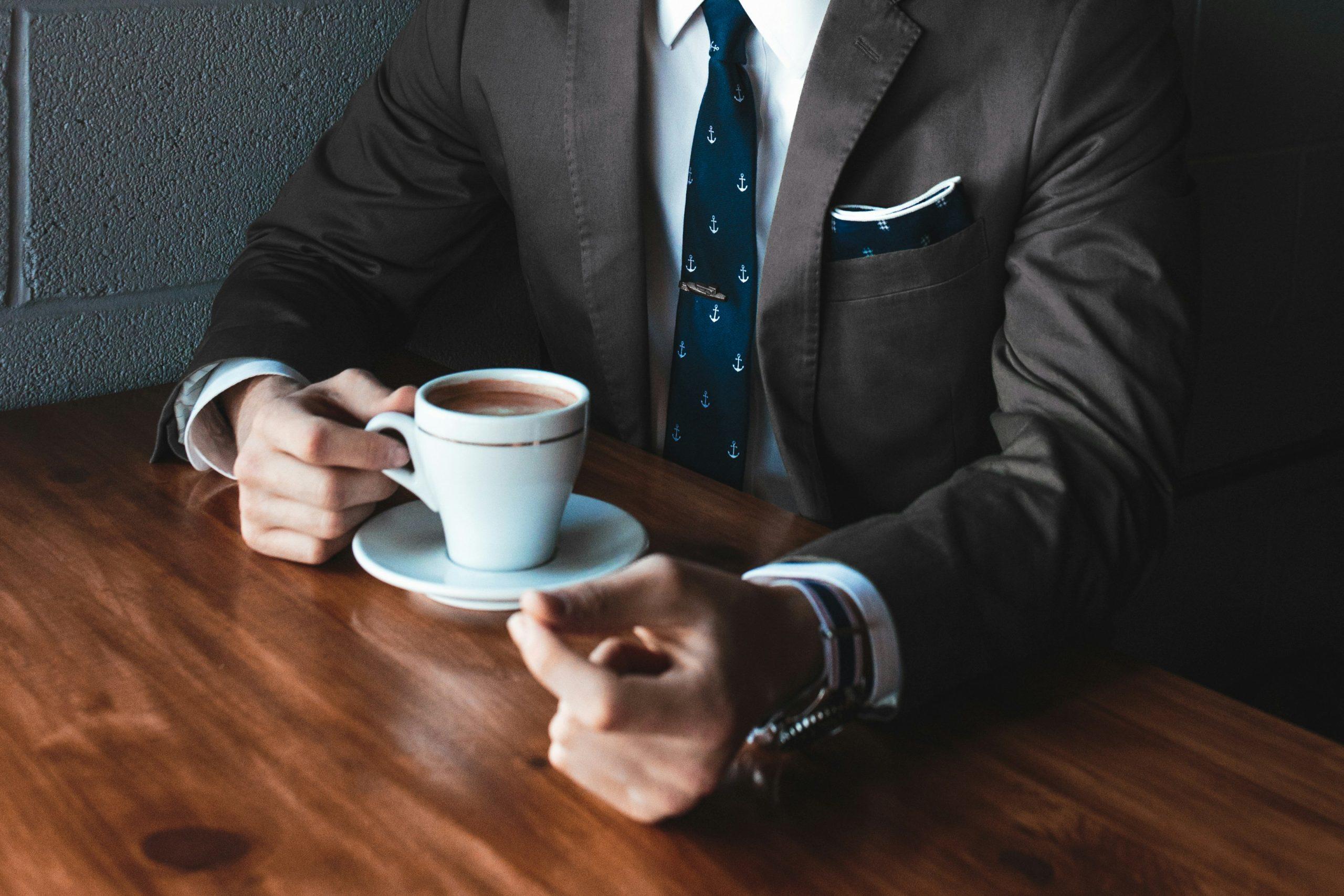 Un homme en costume boit un café