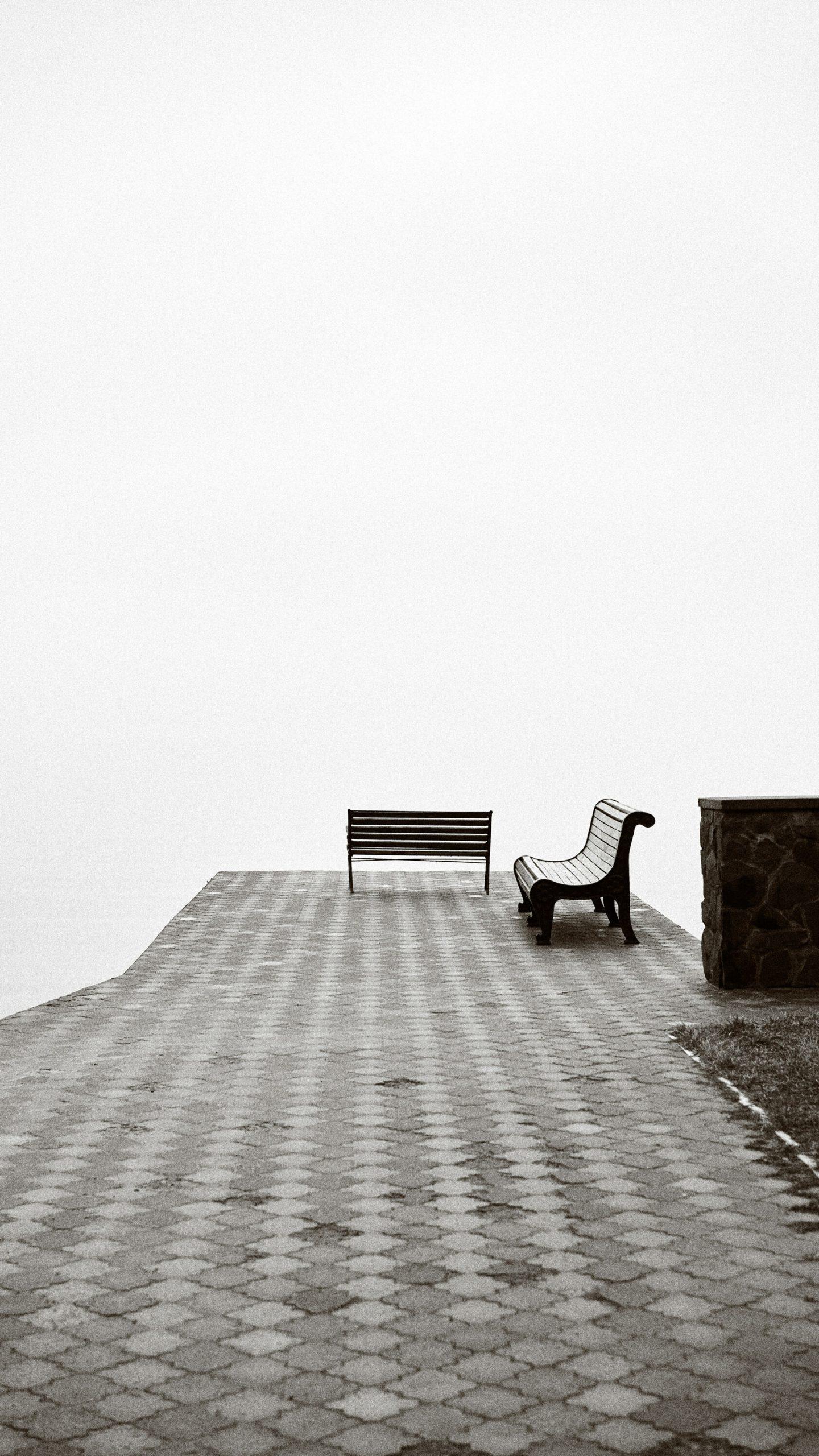 Des bancs dans un espace saturé de blanc.