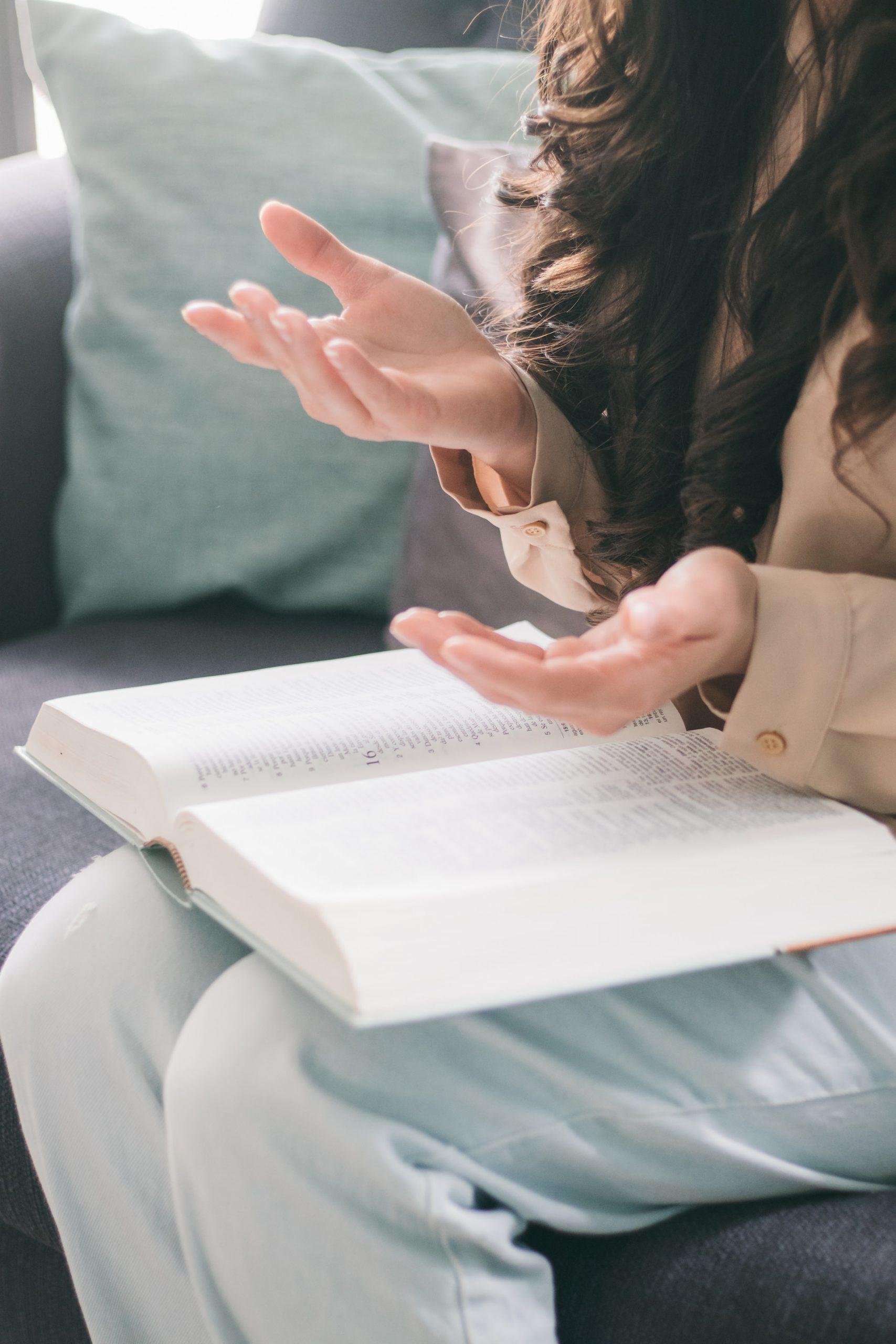 personne en train de parler avec un livre ouvert sur les genoux 