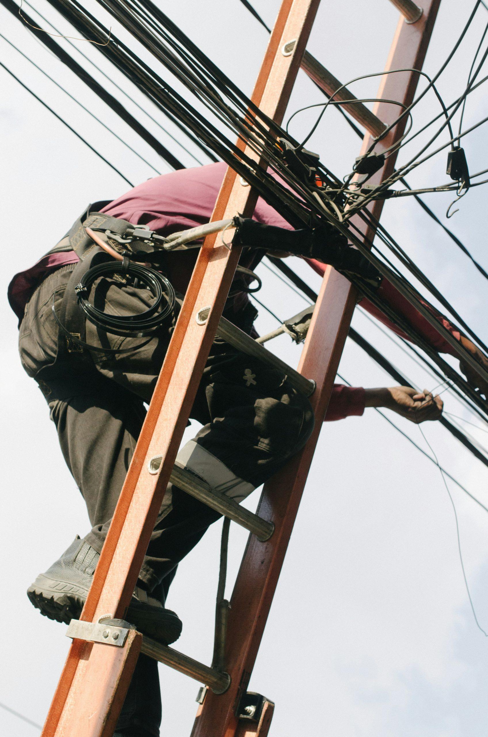 Un homme travaille sur une ligne à haute tension.