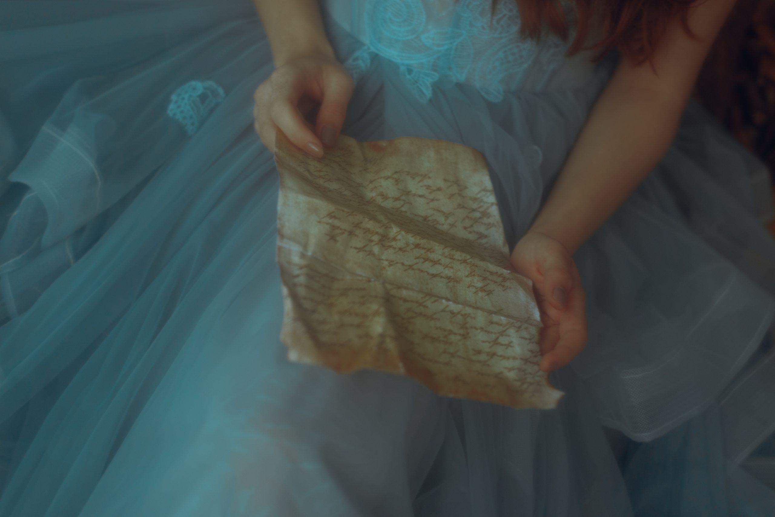 Une lettre froissée dans la main d'une jeune fille.