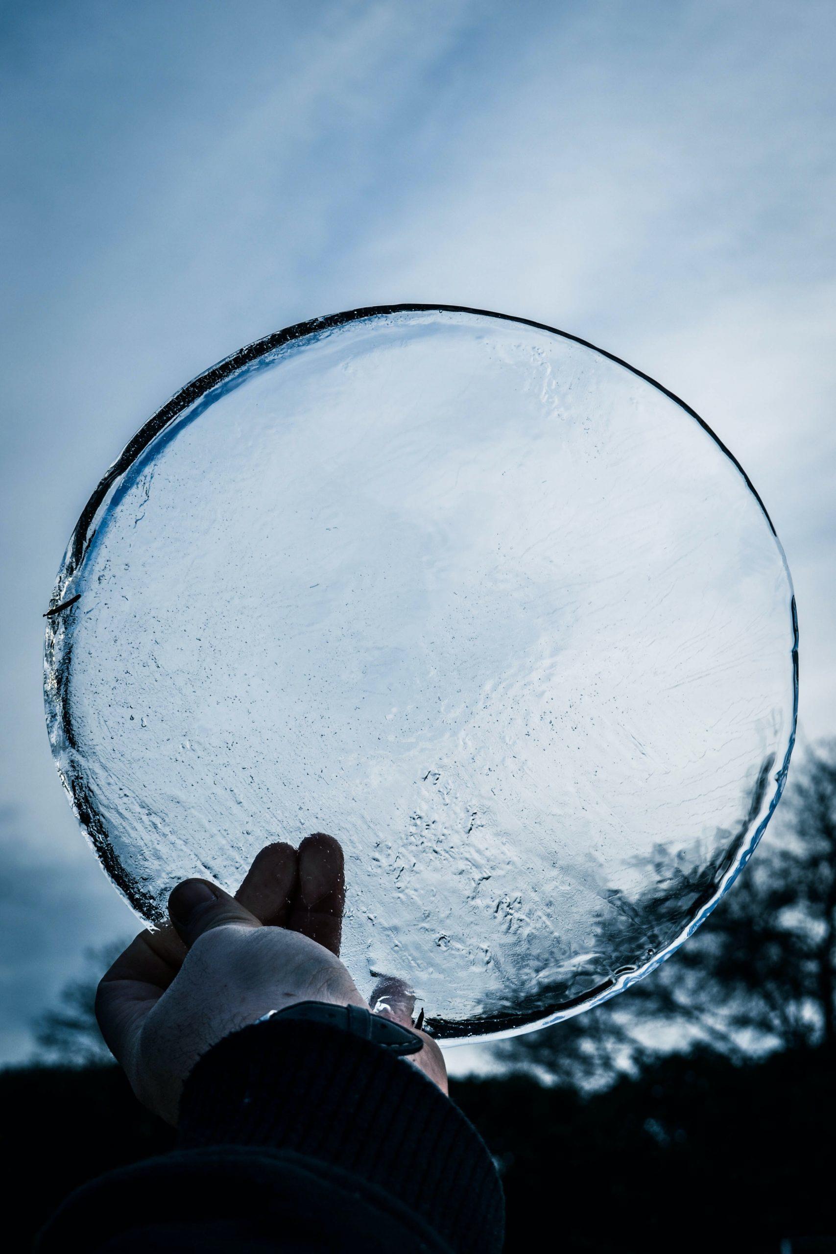 Une main tient un cercle de glace.