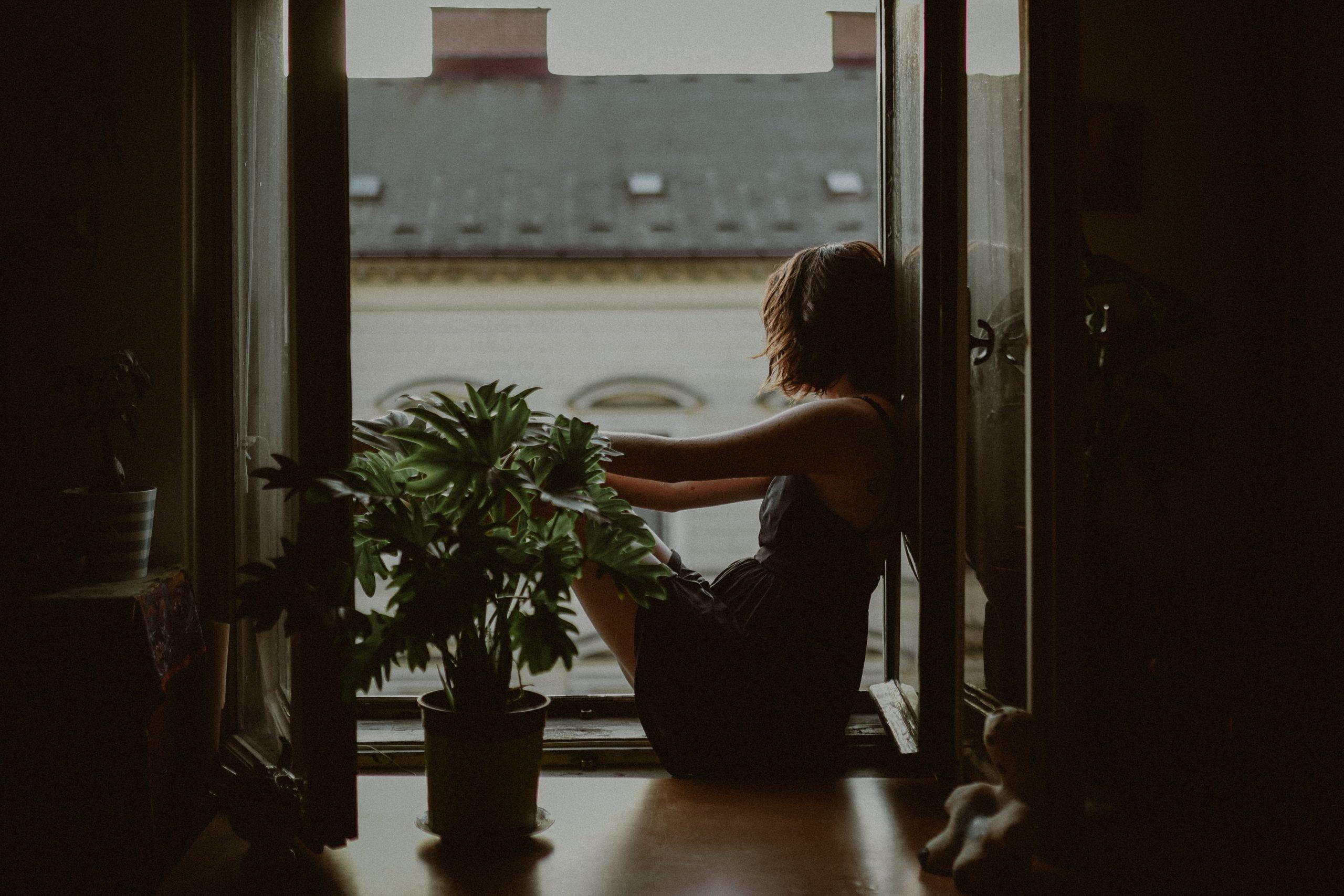 Une fille réfléchit à sa fenêtre.