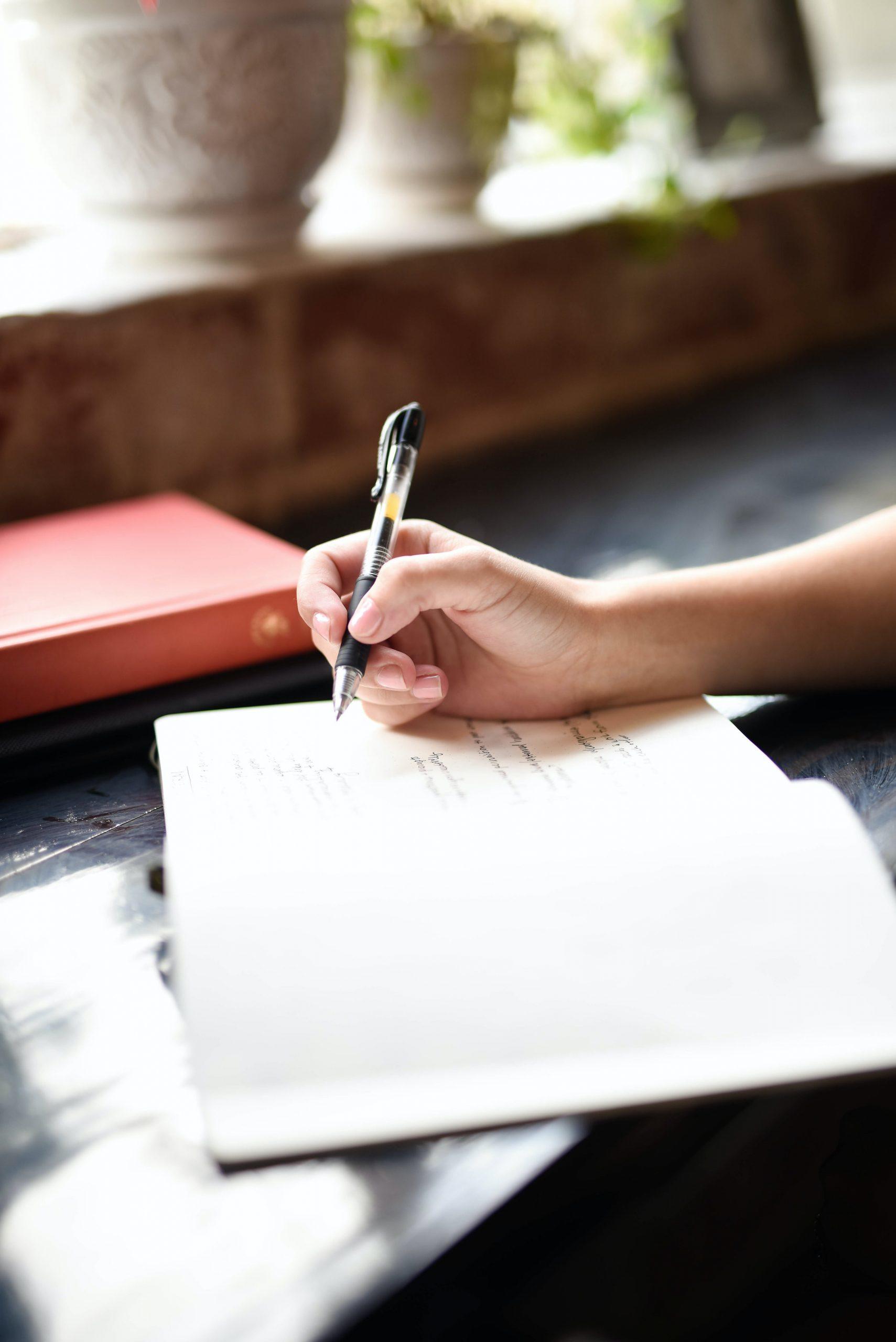 Une lycéenne travaille sur une table le programme de 5ème.