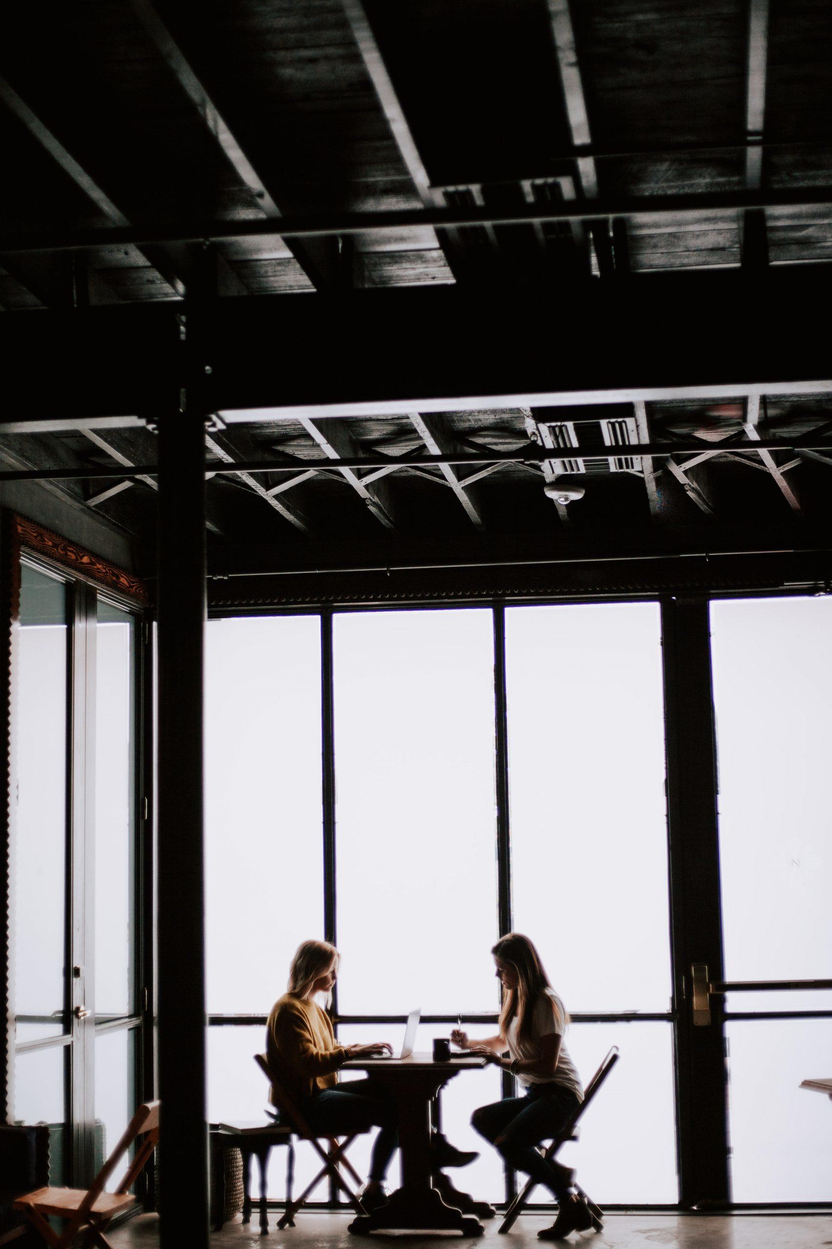 Deux futures clientes discutent dans une grande salle.