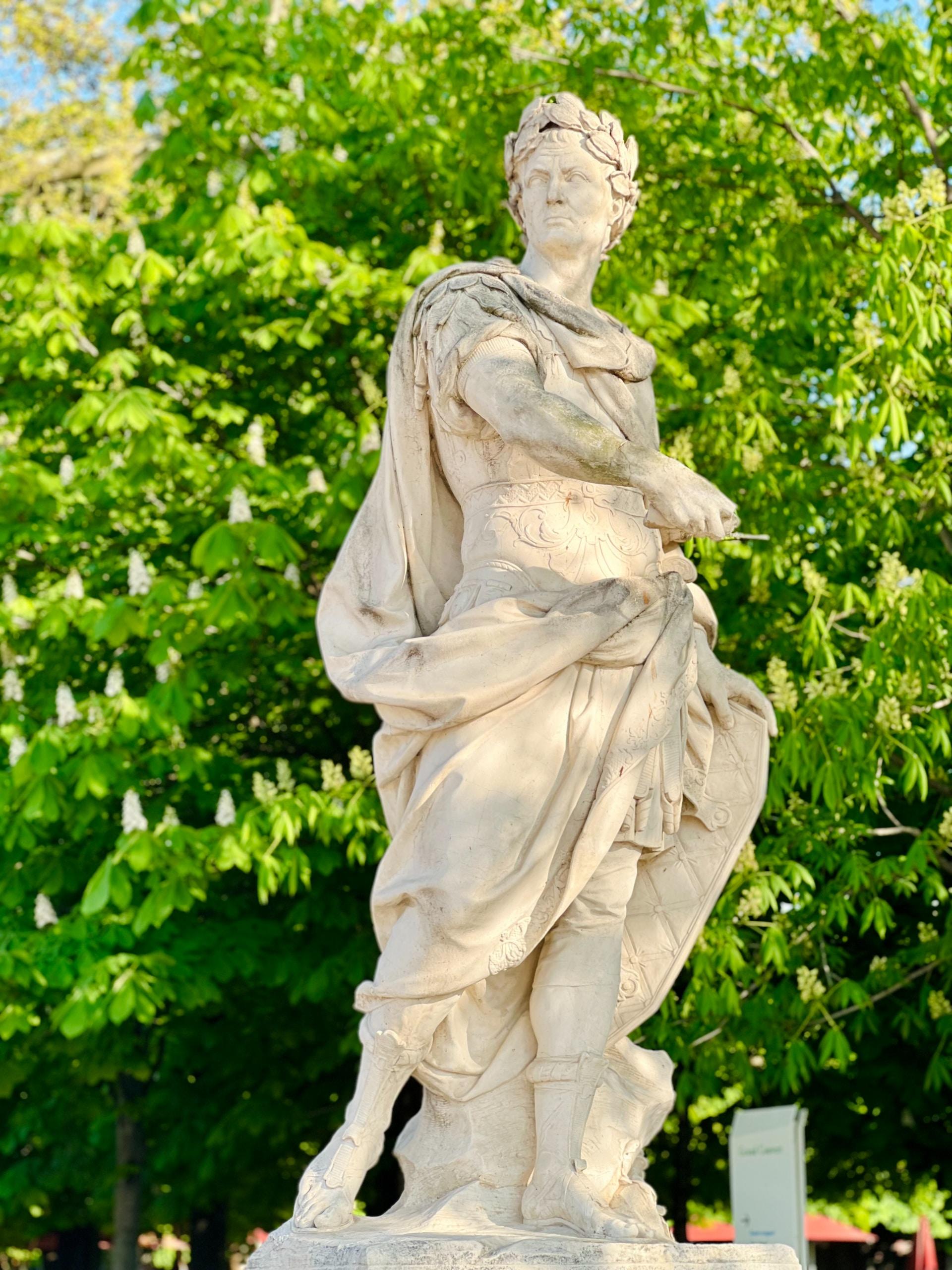 statue en extérieur devant un buisson 