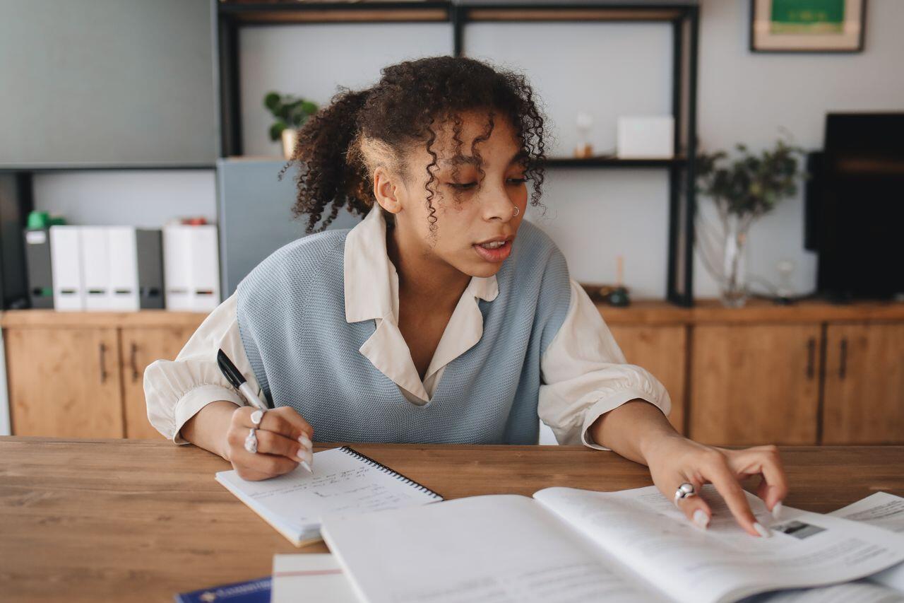 jeune femme avec un tricot bleu ciel tres concentree sur son travail