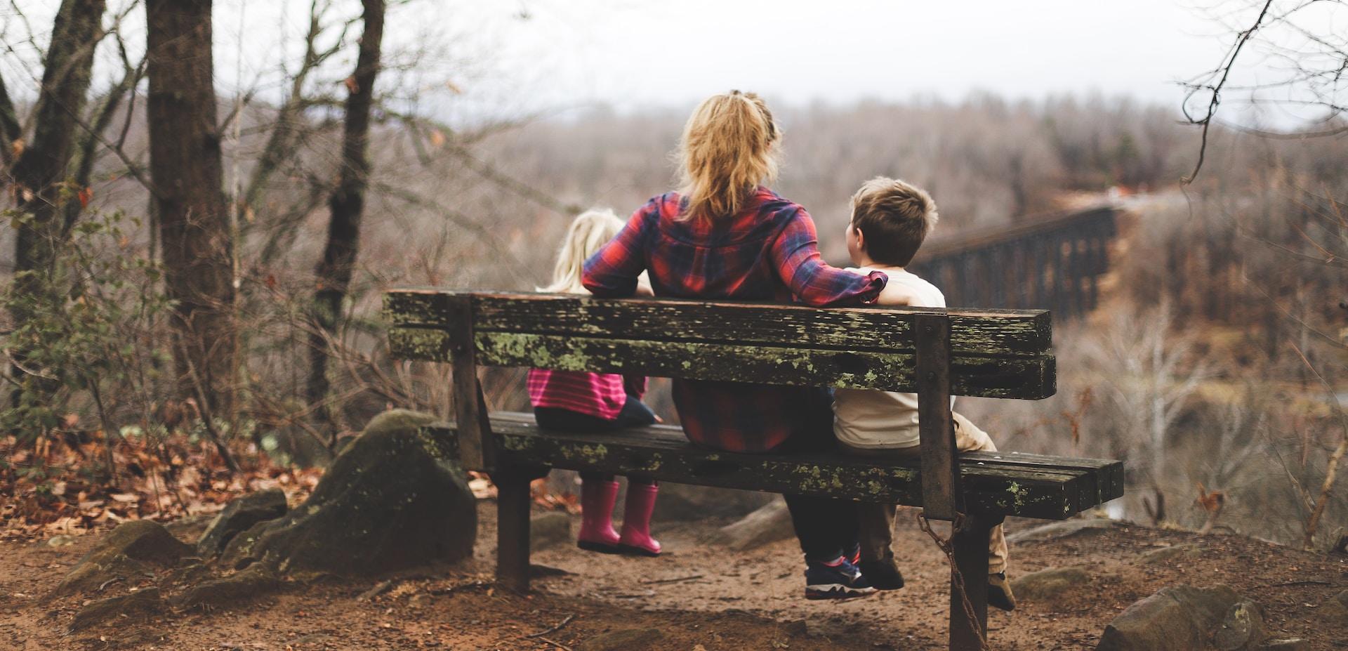 une mère avec ses enfants sur un banc 