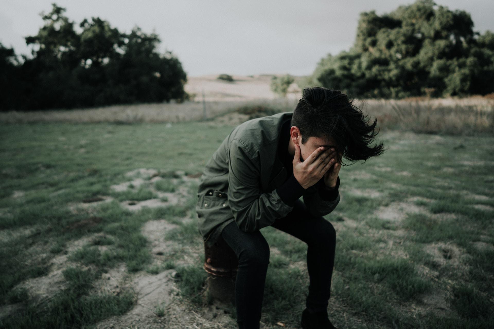 un jeune sur un terrain vague en train de pleurer