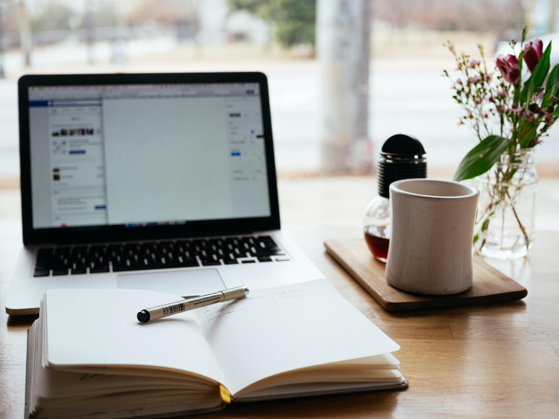 ordinateur et cahier de révisions sur un bureau