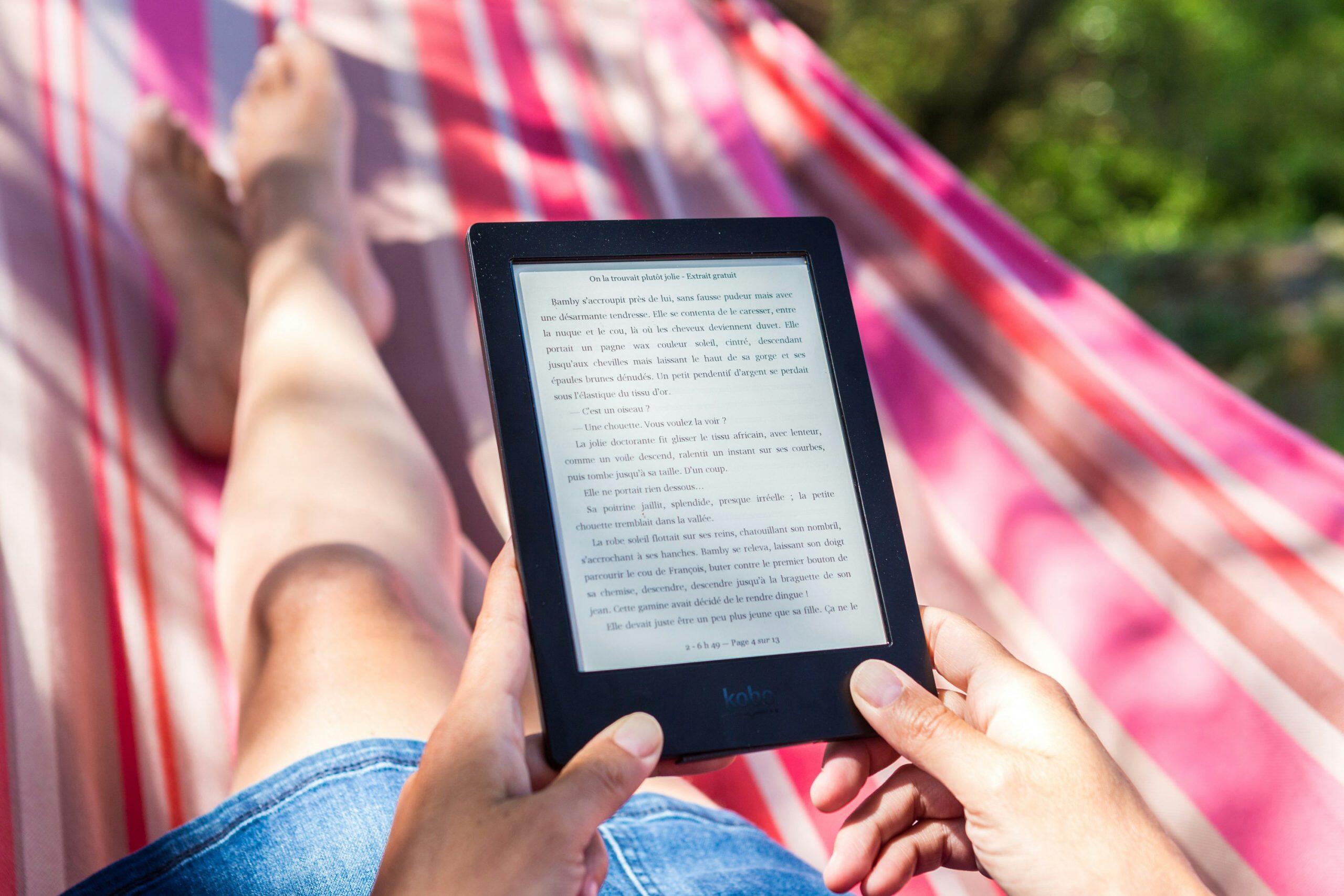 Une femme lit un livre électronique.