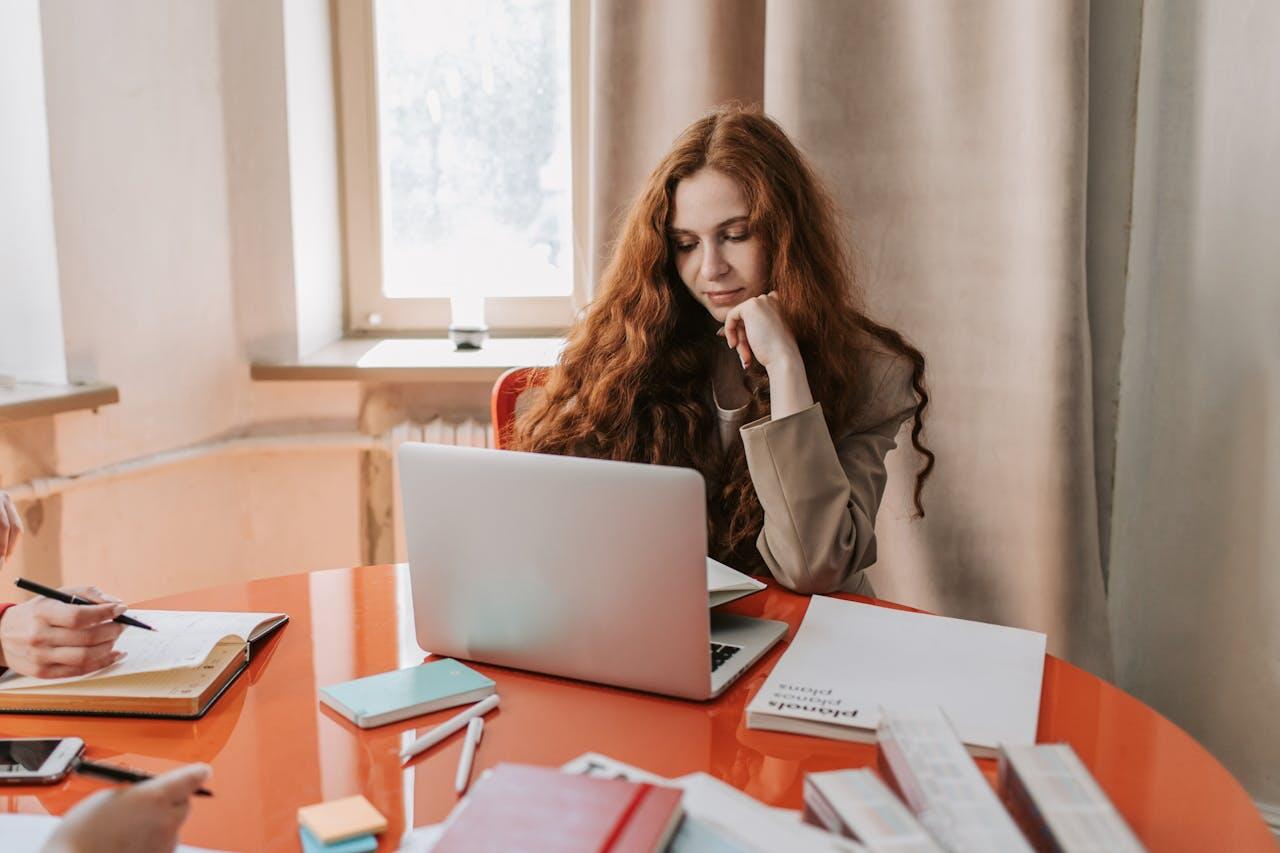 jeune femme etudiant sur table avec laptop et un tas de cahiers