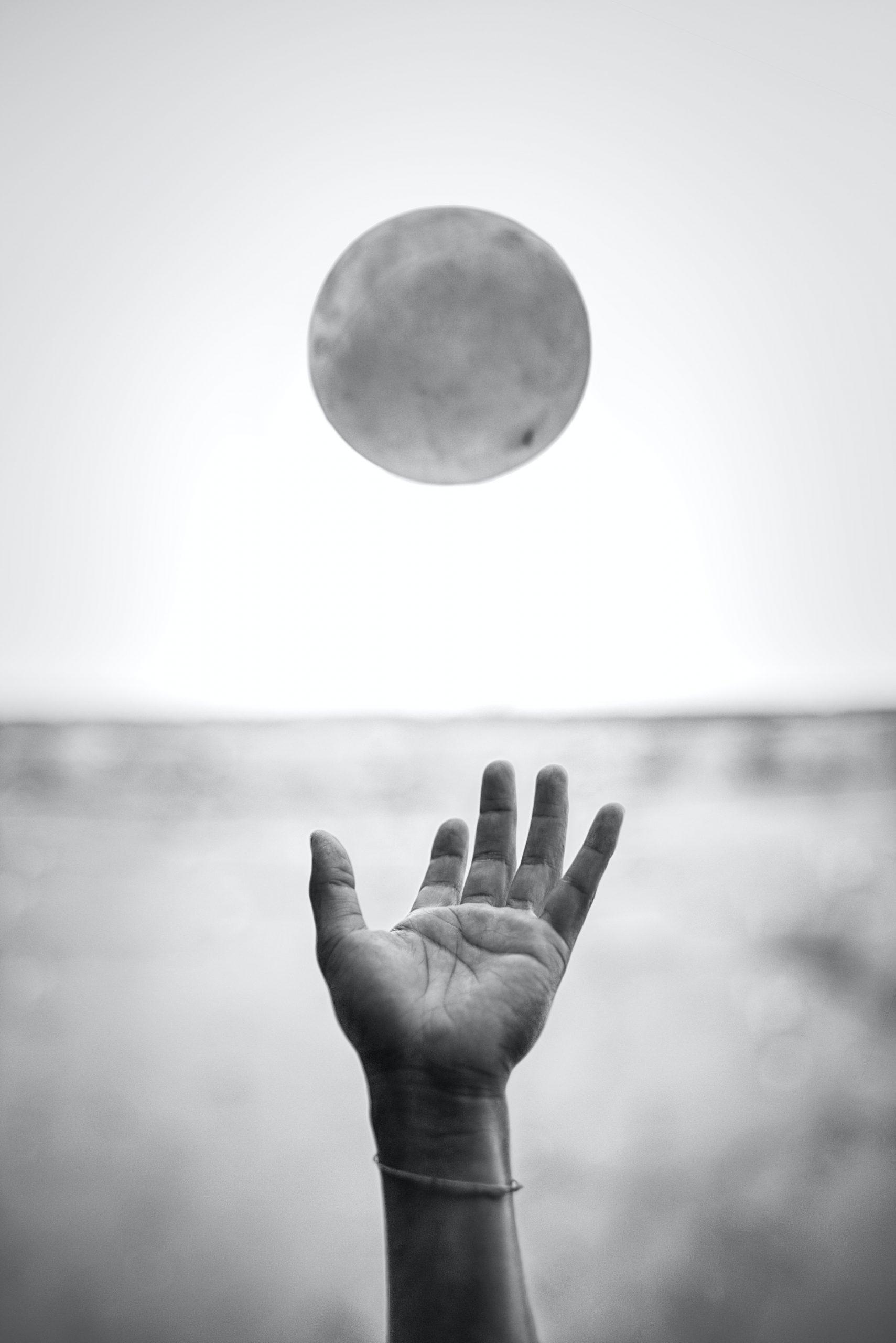Une main tendue vers un ballon.