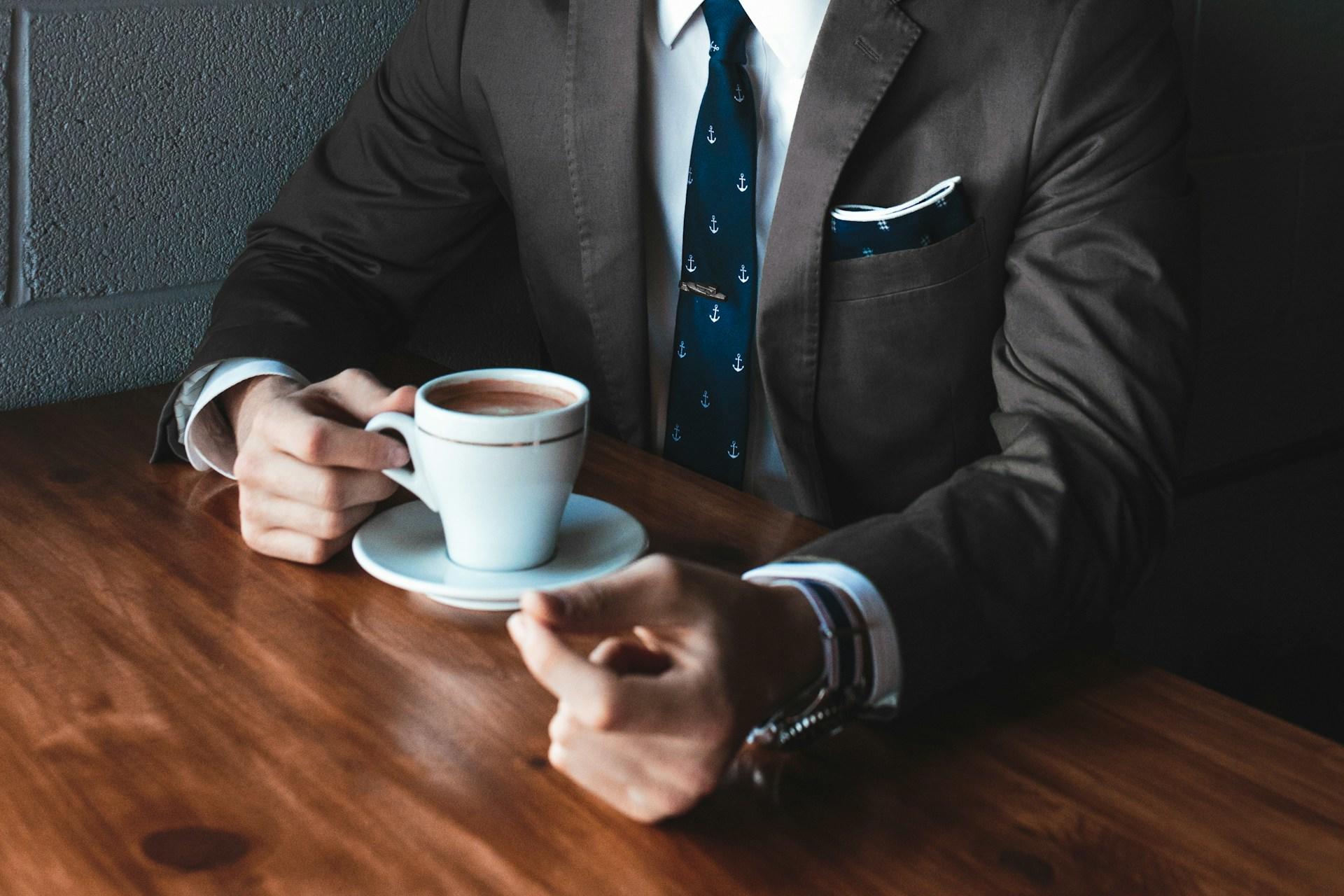 personne en costume en train de boire un café 