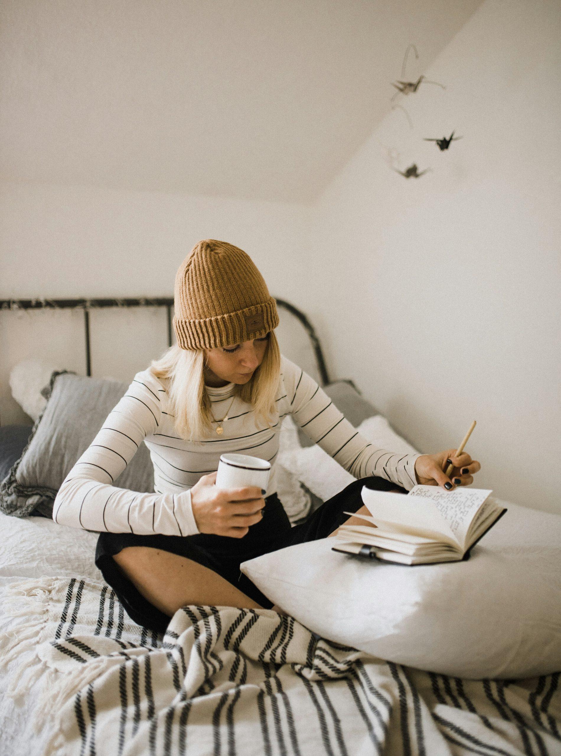 Une étudiante fait des exercices d'anglais sur son lit.