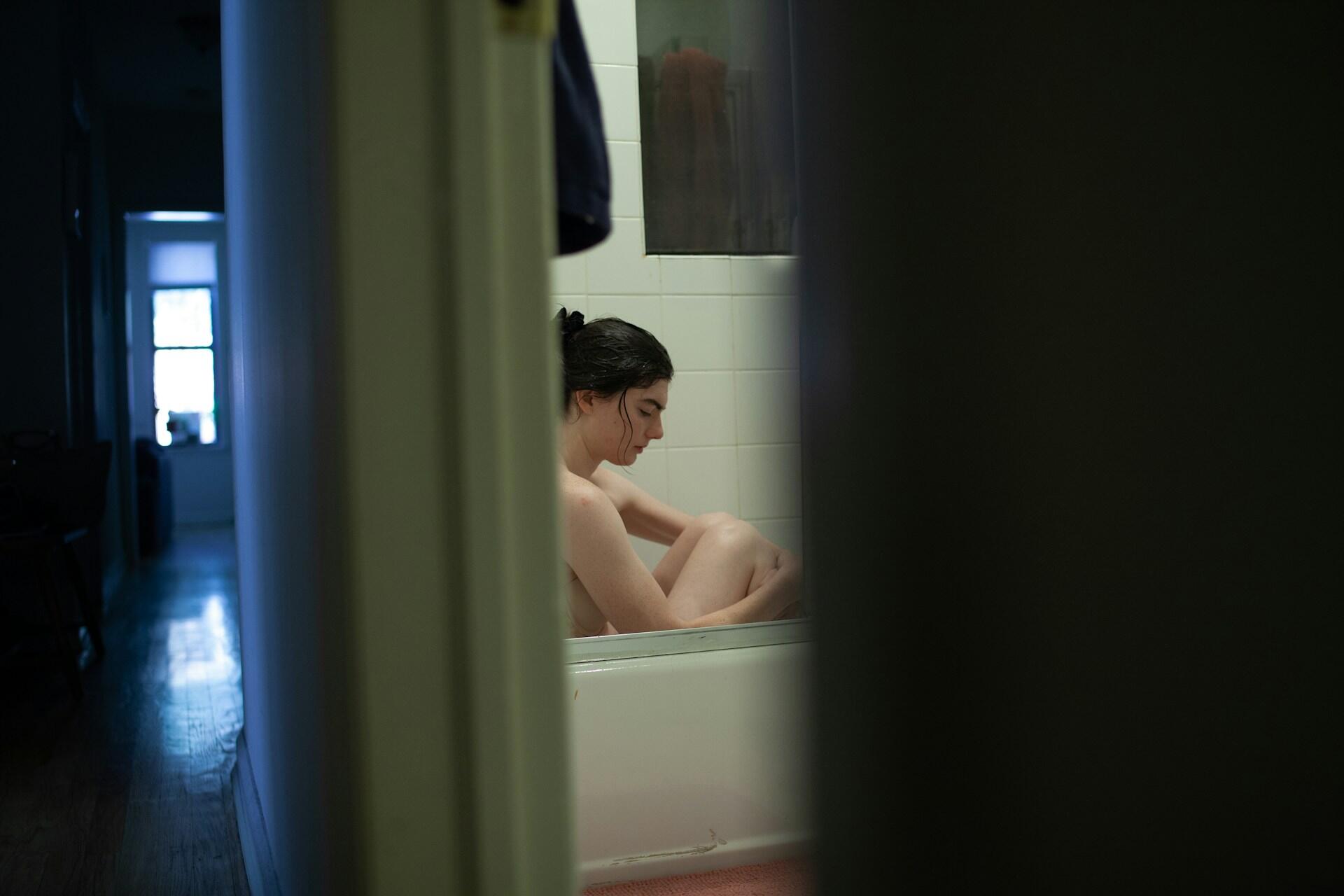 Femme nue dans un bain, vue de l'extérieur de la pièce
