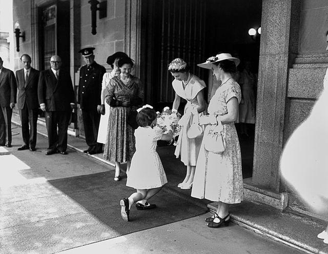 Queen Elizabeth being given flowers by a little girl in Brisbane