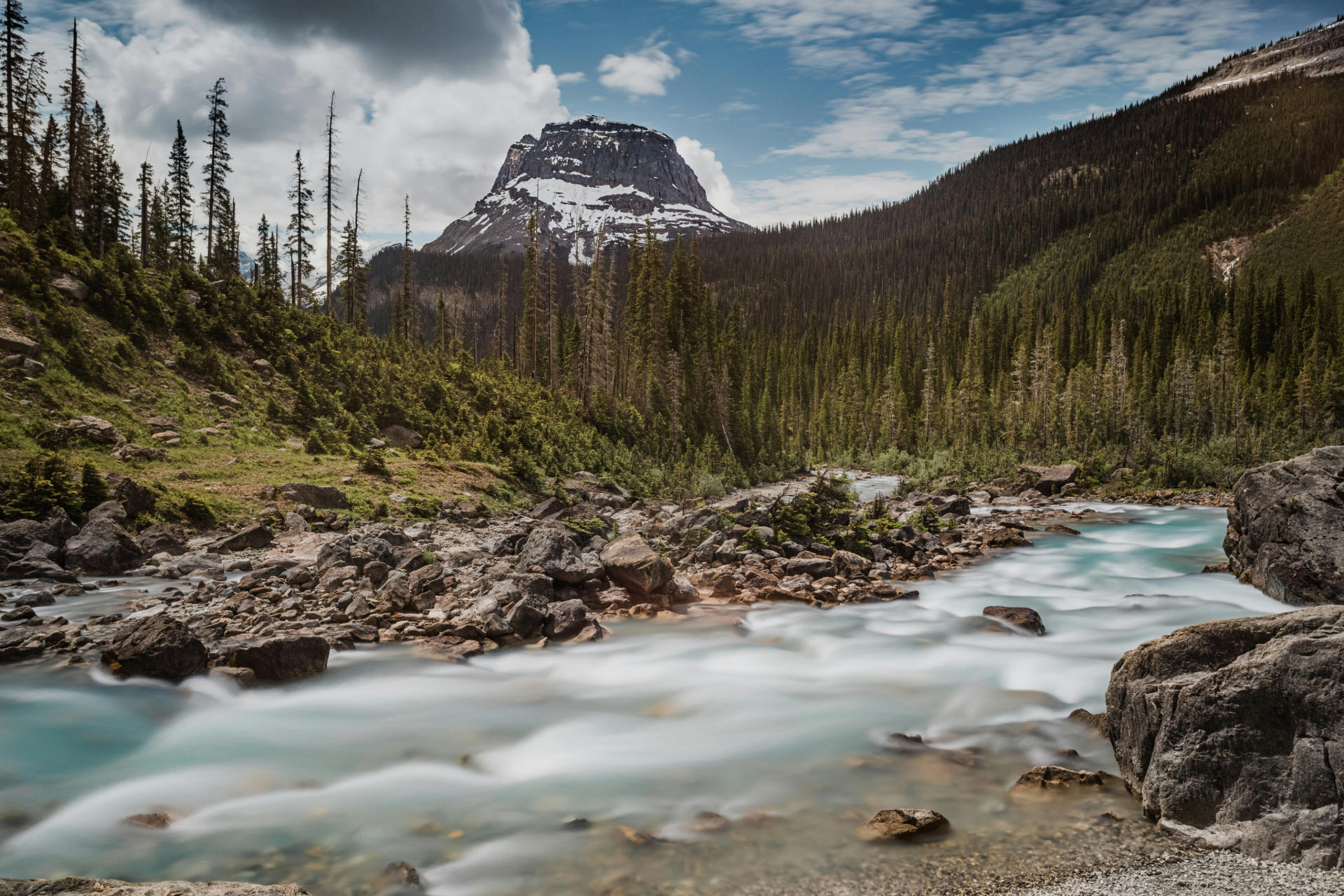 image of a mountain with a fast flowing river in front of it 