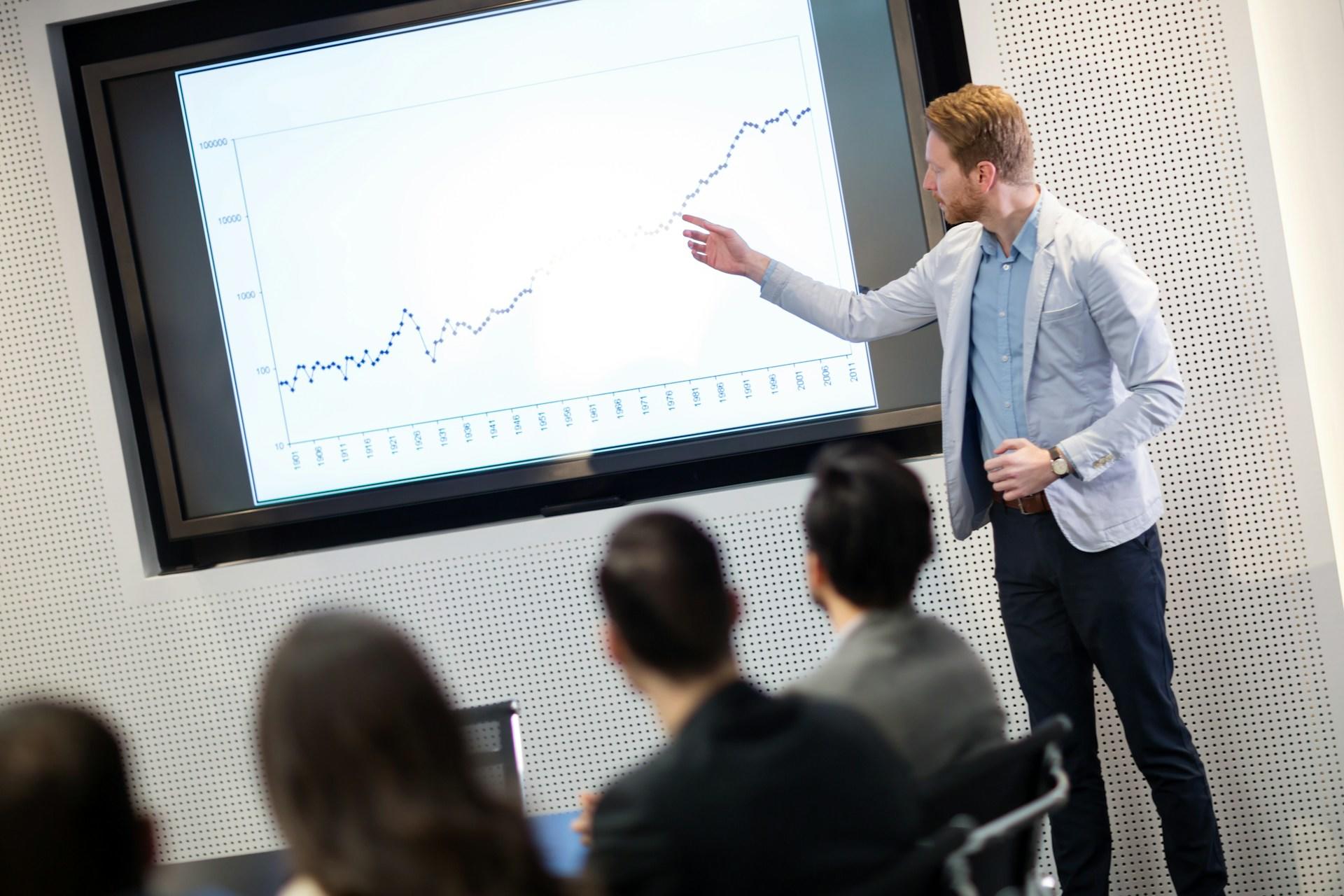 man presenting a graph showing economic growth